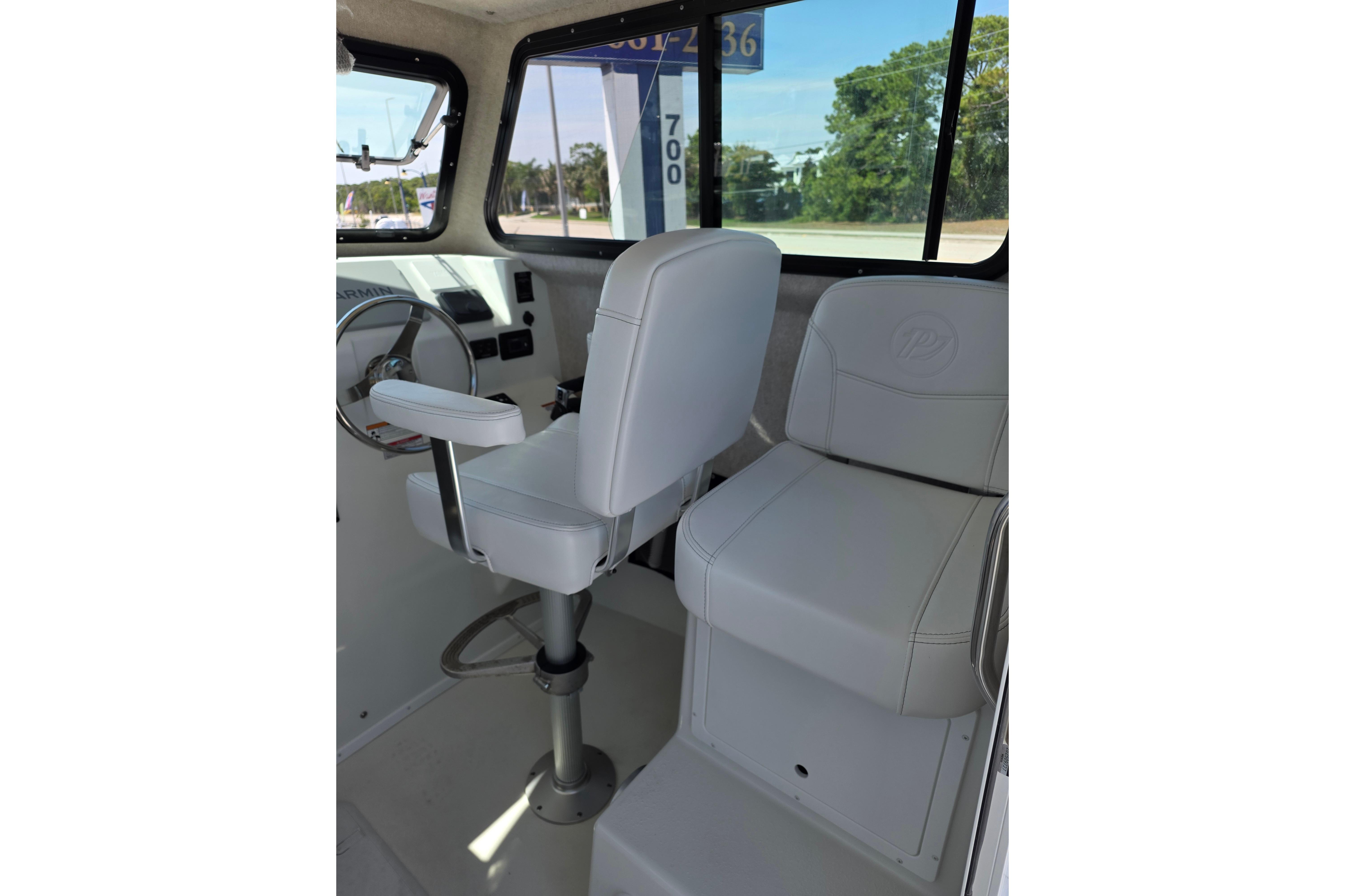 Interior of 2026 Parker 287 Explorer boat with white seating and steering wheel.