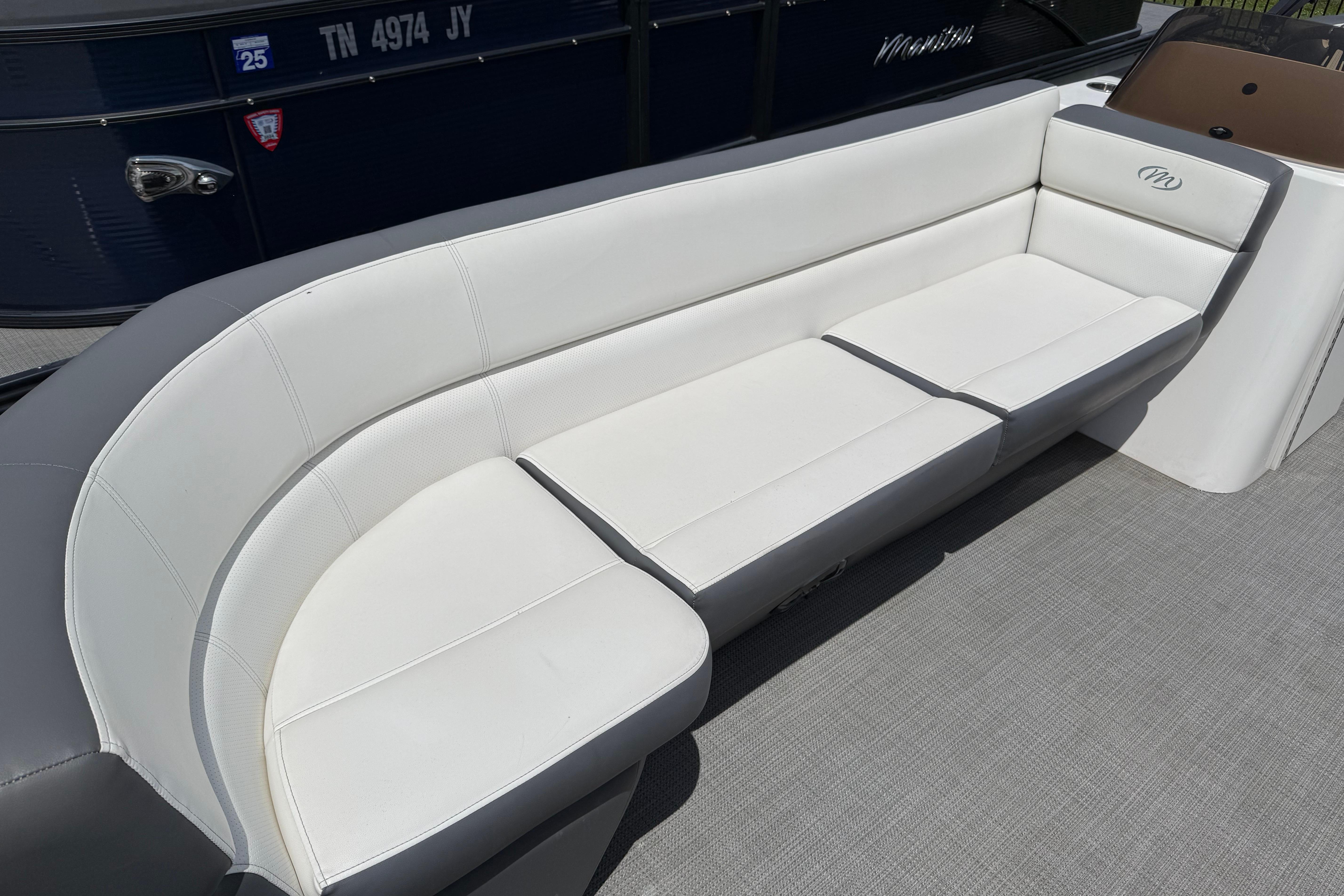 2022 Manitou Aurora LE boat with white cushioned seating.