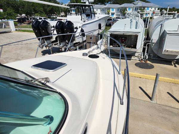 2005 Pursuit 3070 Offshore Center Console boat docked with other vessels nearby.