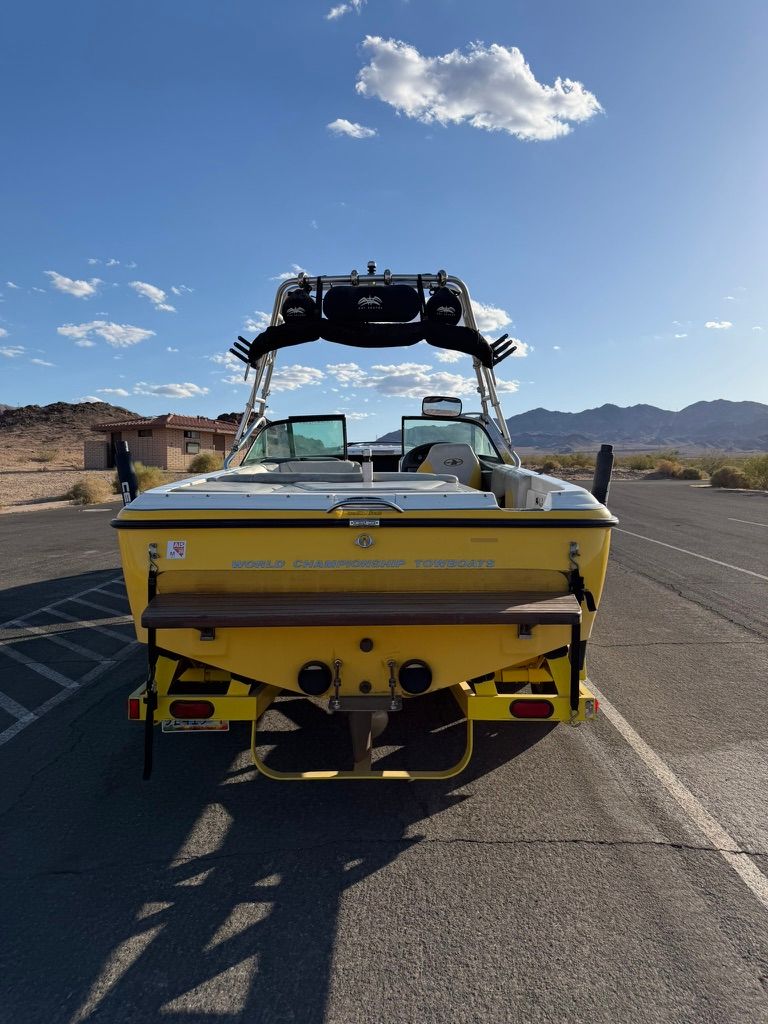 Yellow 2003 Centurion Avalanche boat on parking lot.