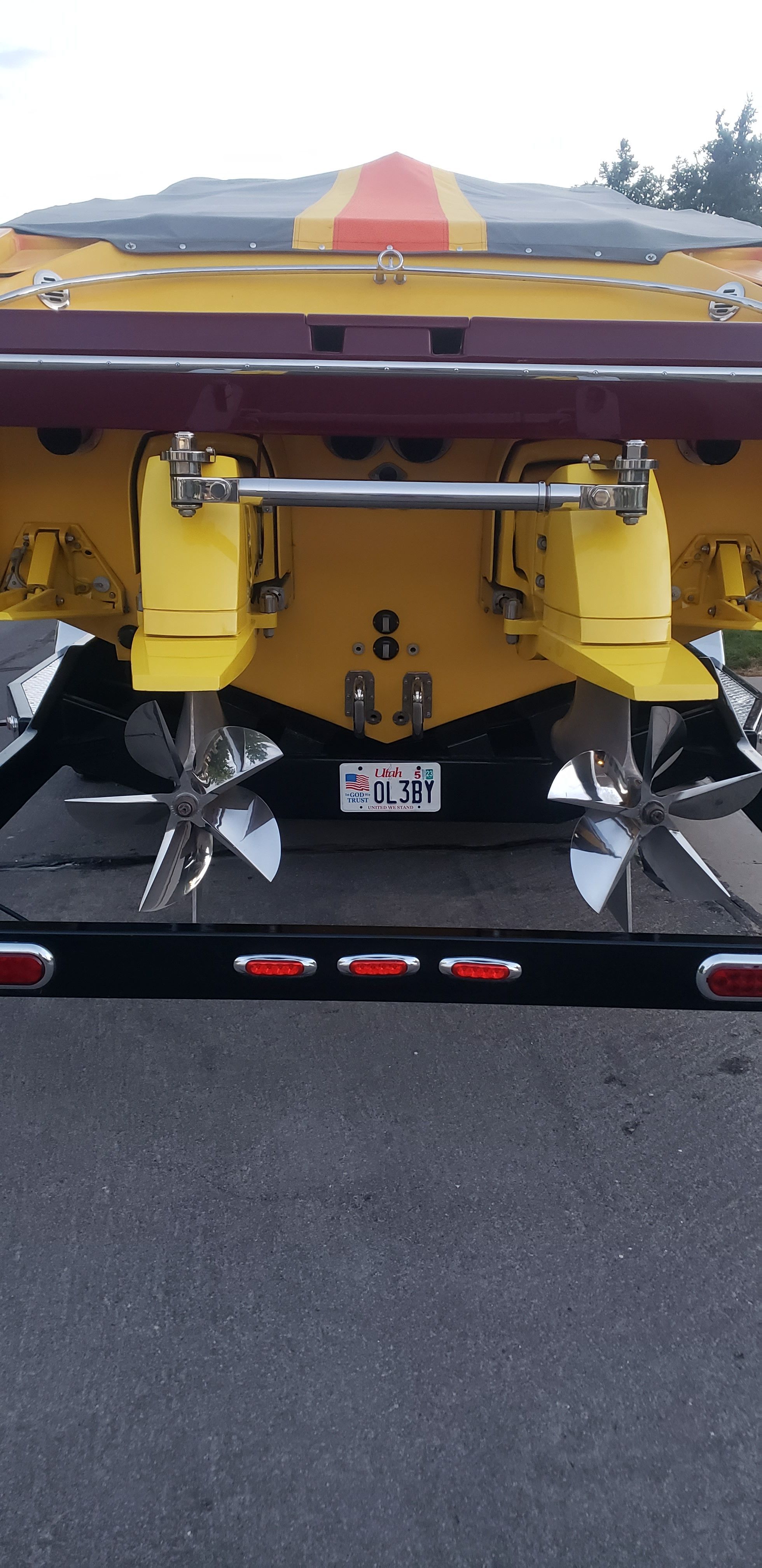 Rear view of a yellow 2009 Hallett 400T boat on a trailer.