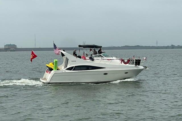 2004 Carver 360 Mariner yacht cruising on a calm waterway, adorned with flags.