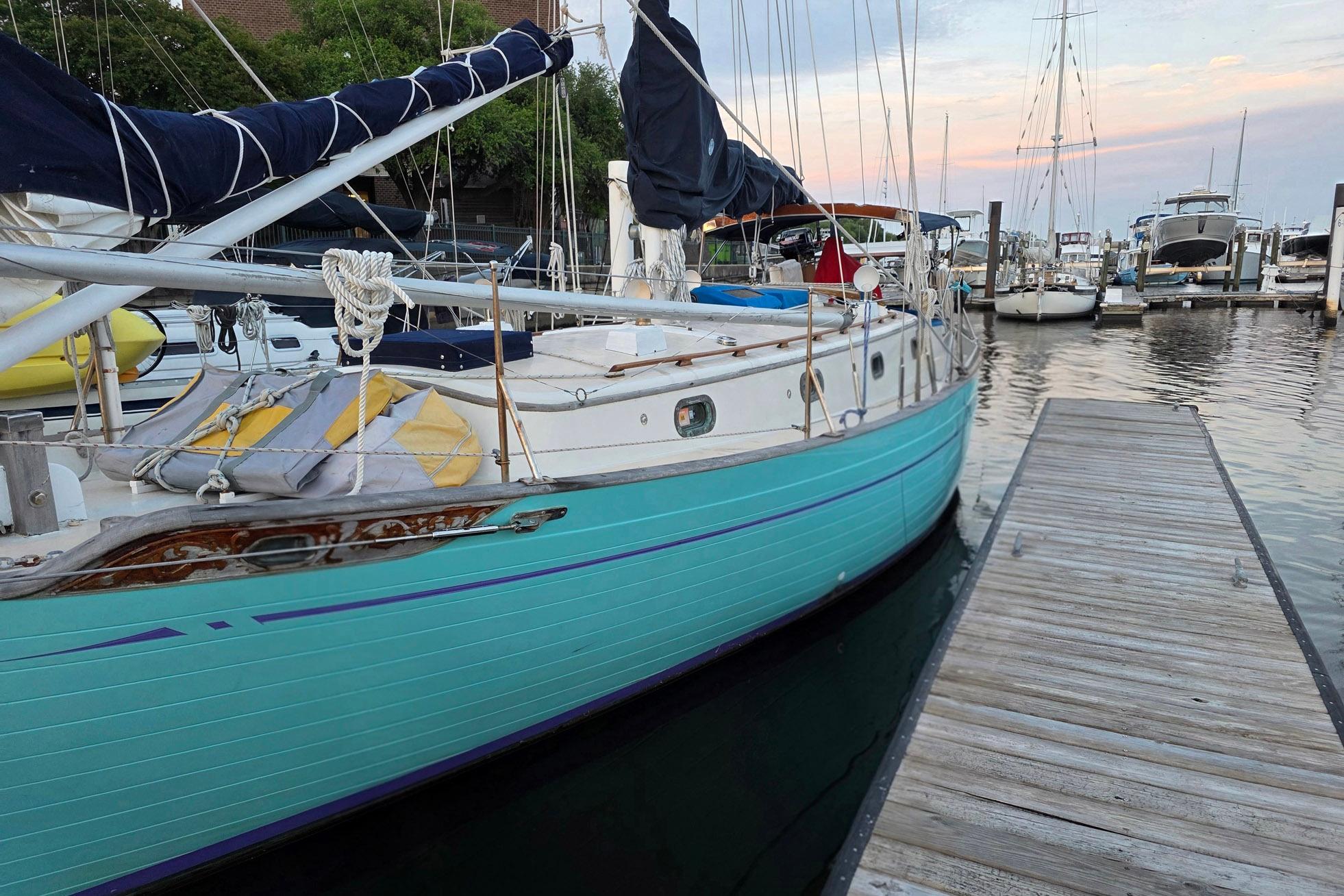 1982 Tayana 37 sailboat docked at marina during sunset.