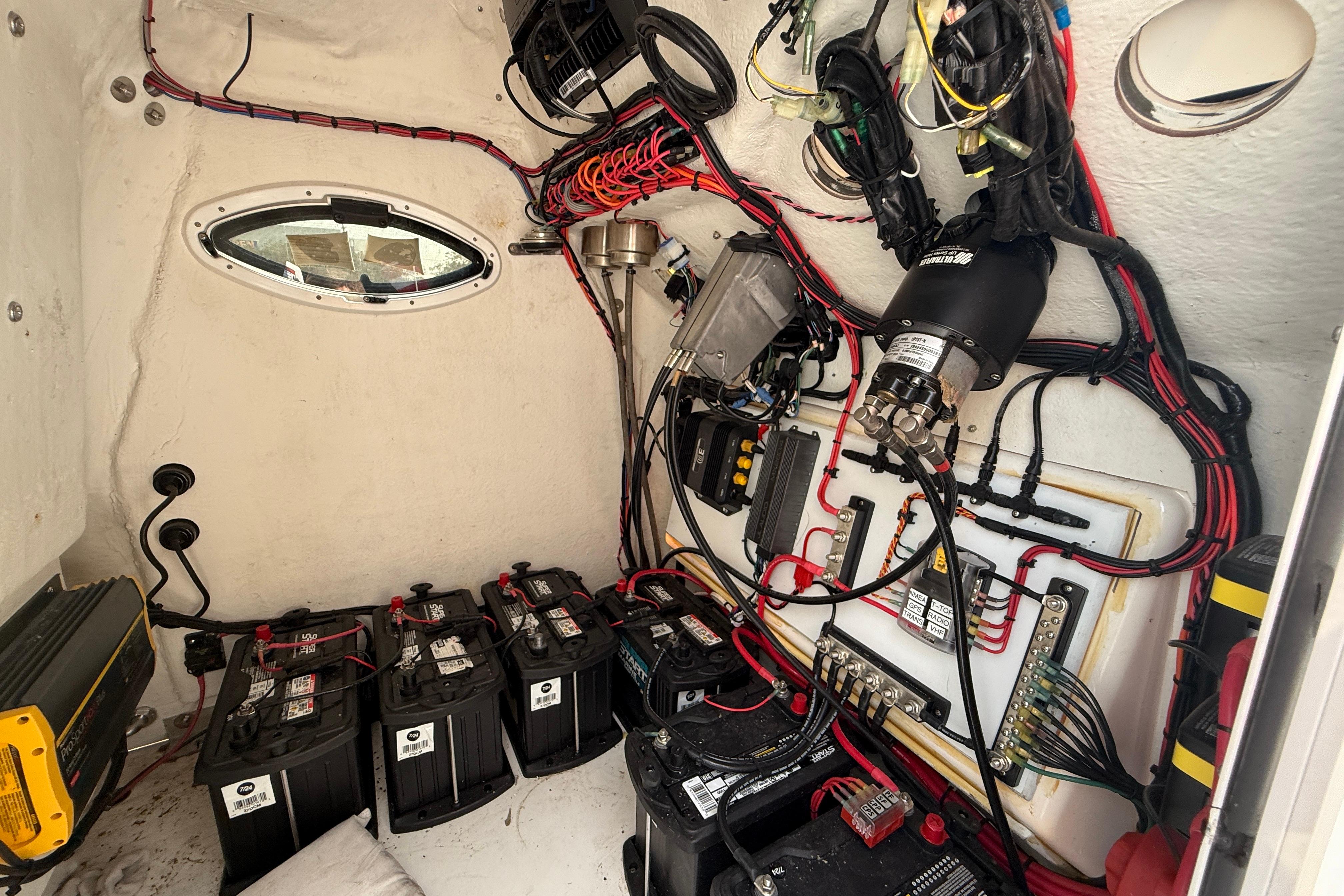 Electrical system inside 2020 Twin Vee 240 GFX CC boat, featuring batteries and wiring.