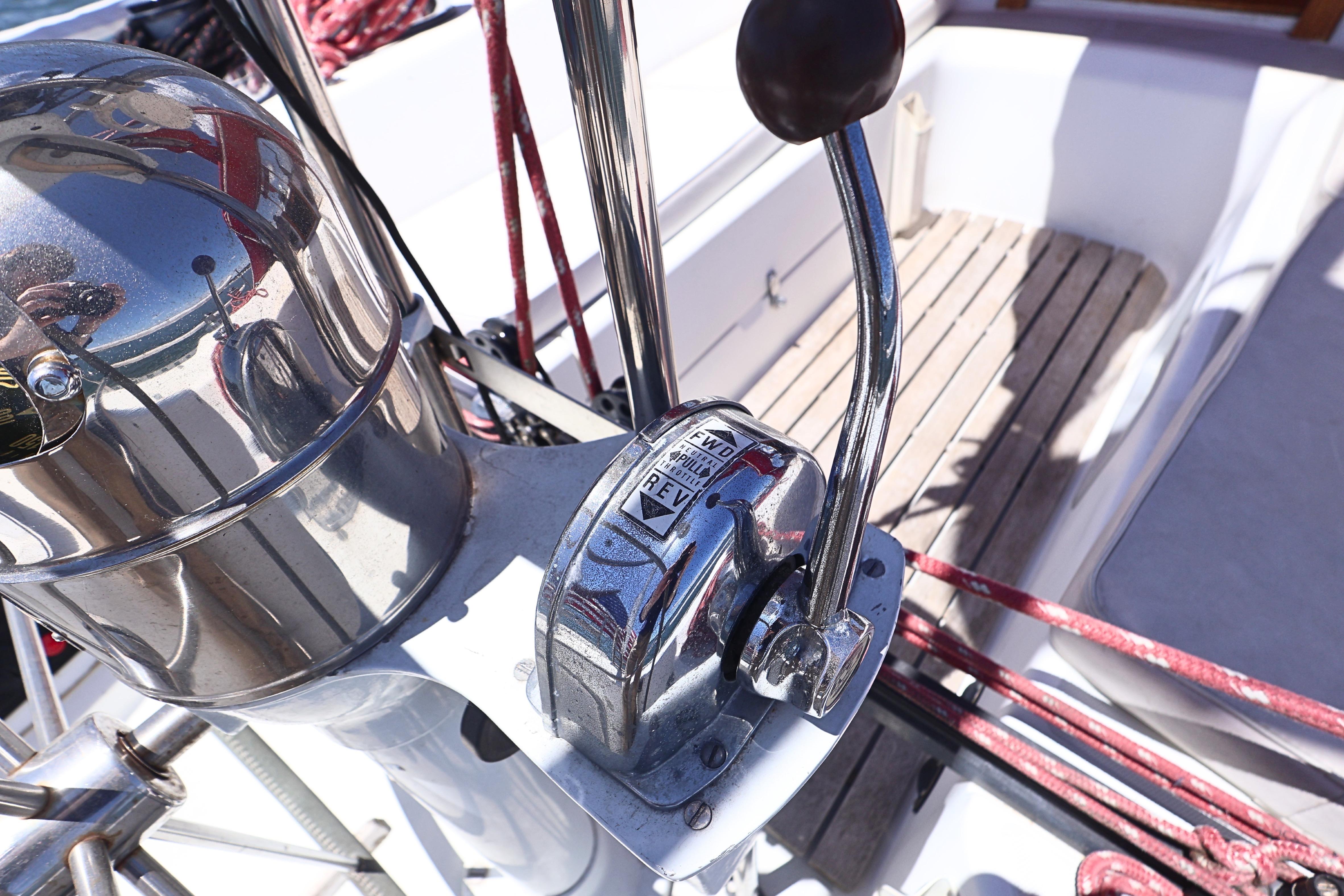 Cockpit controls of a 1989 J Boat J 40 sailboat, featuring throttle and compass.