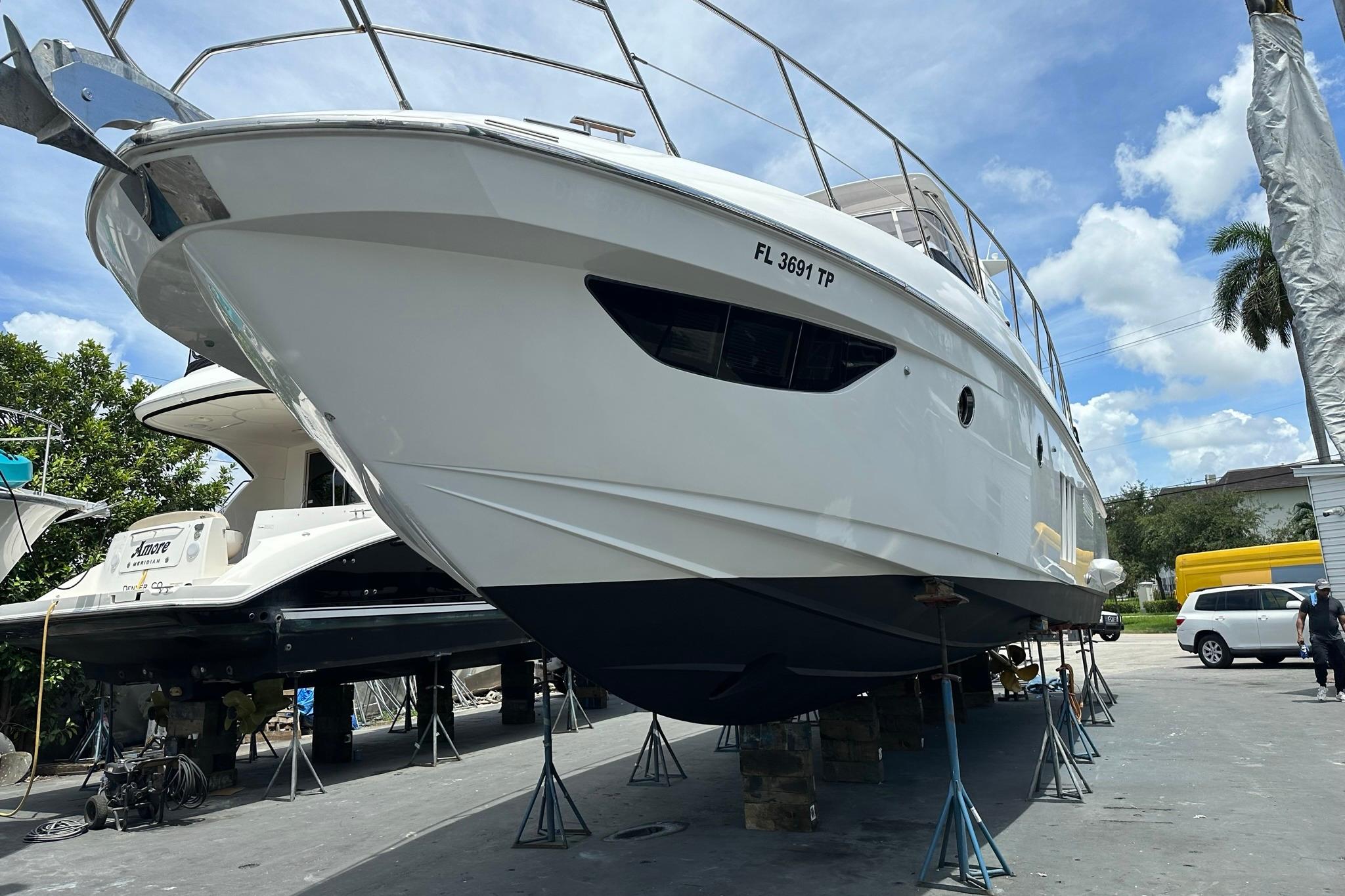 2013 Azimut Fly 53 yacht on stands, ready for maintenance under a clear blue sky.
