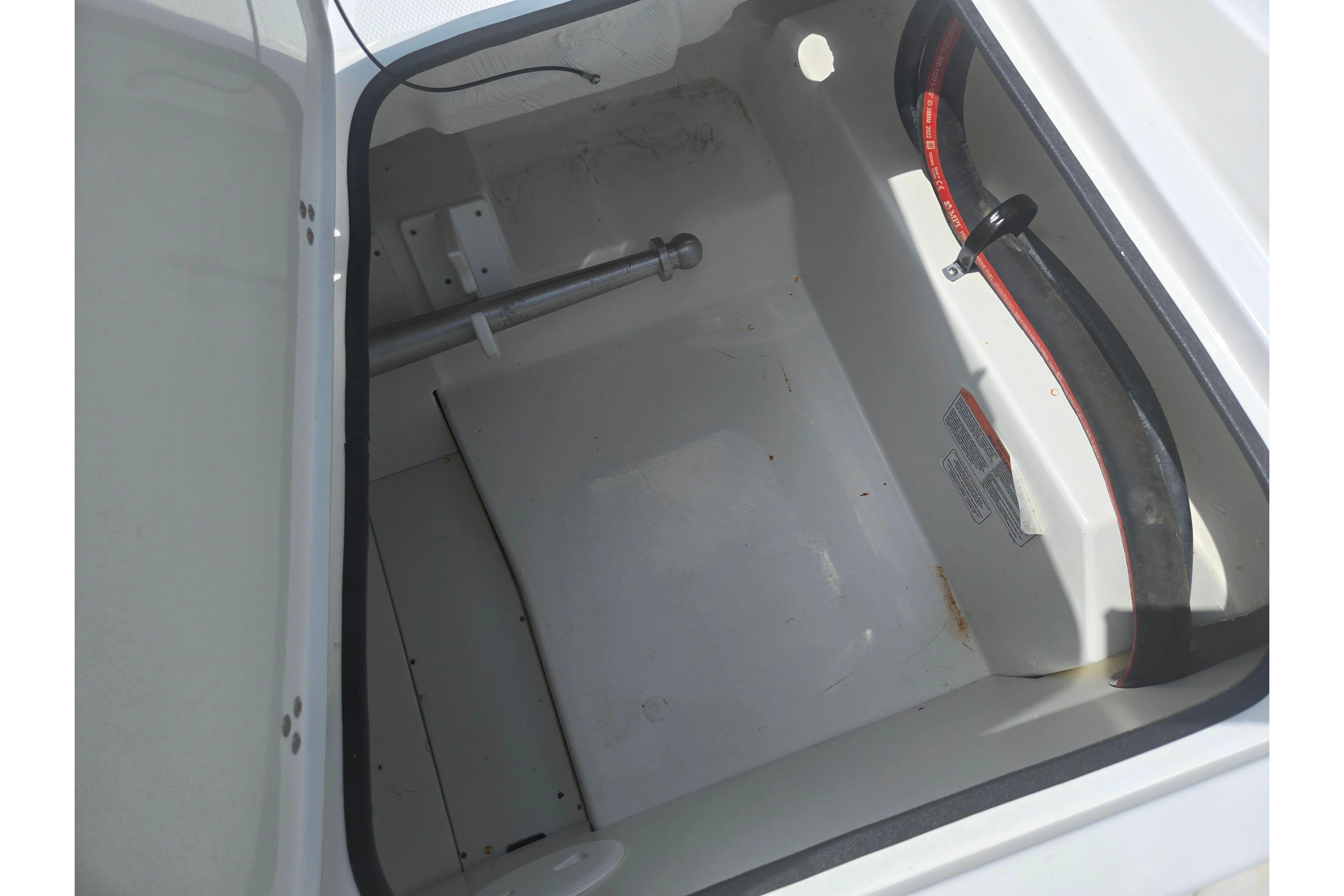 Open storage compartment in 2023 Tahoe 200 S boat, showing interior details and components.