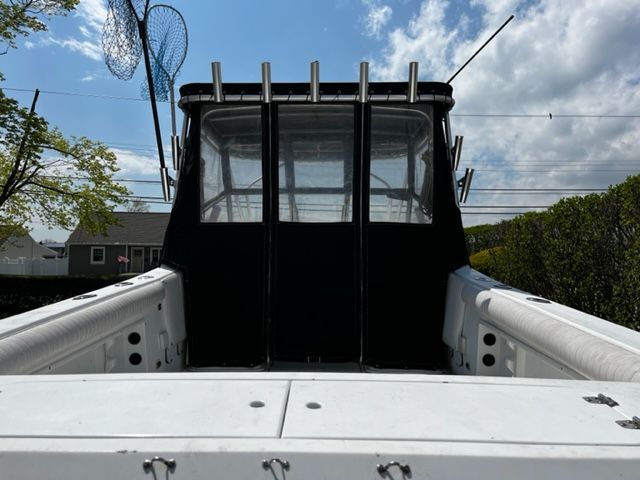 The image shows the cockpit of a 1998 Sport-Craft 252 Sport Fish boat with rod holders.