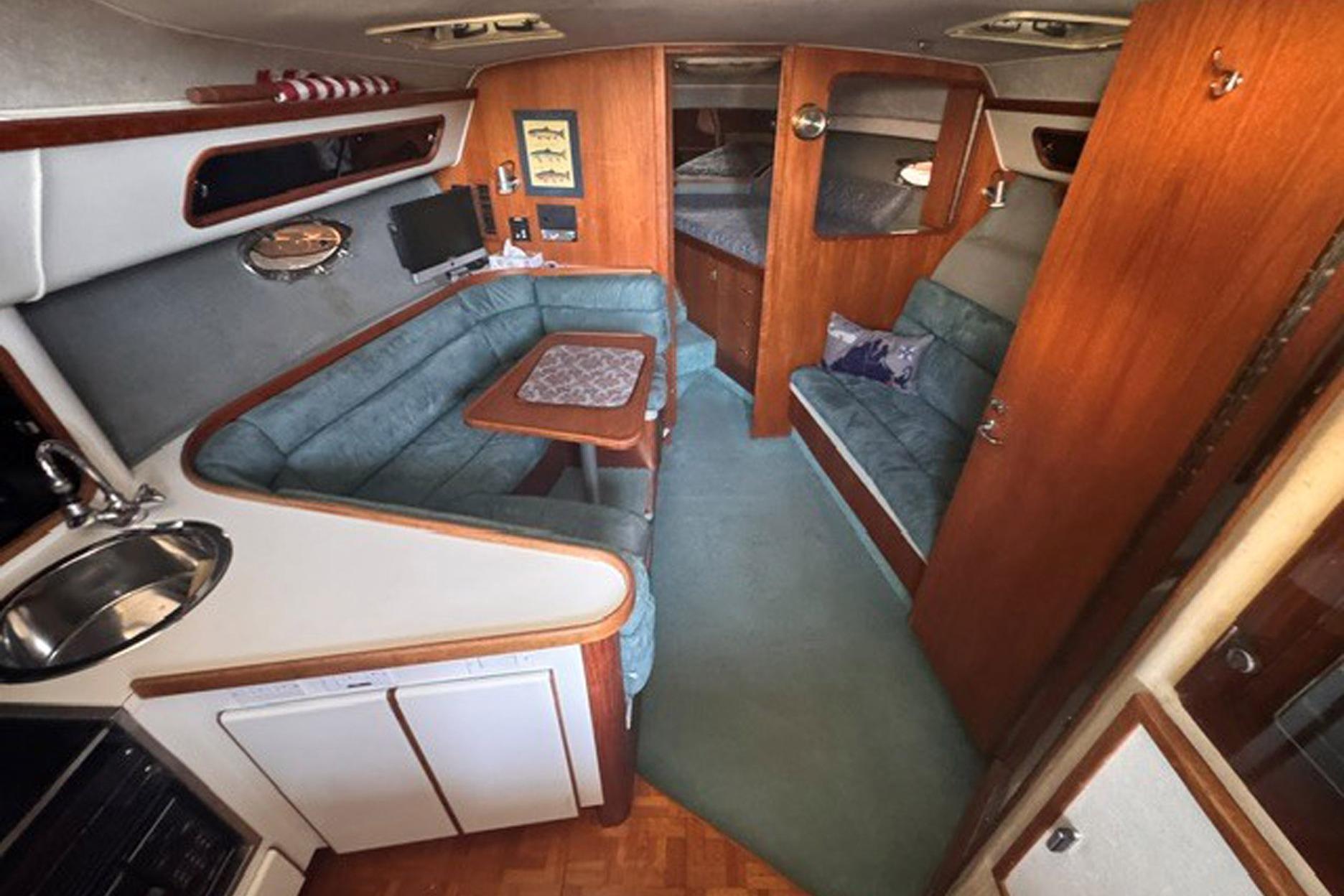 Interior of a 1988 Tiara Yachts 3300 Open, featuring cozy seating and wooden accents.