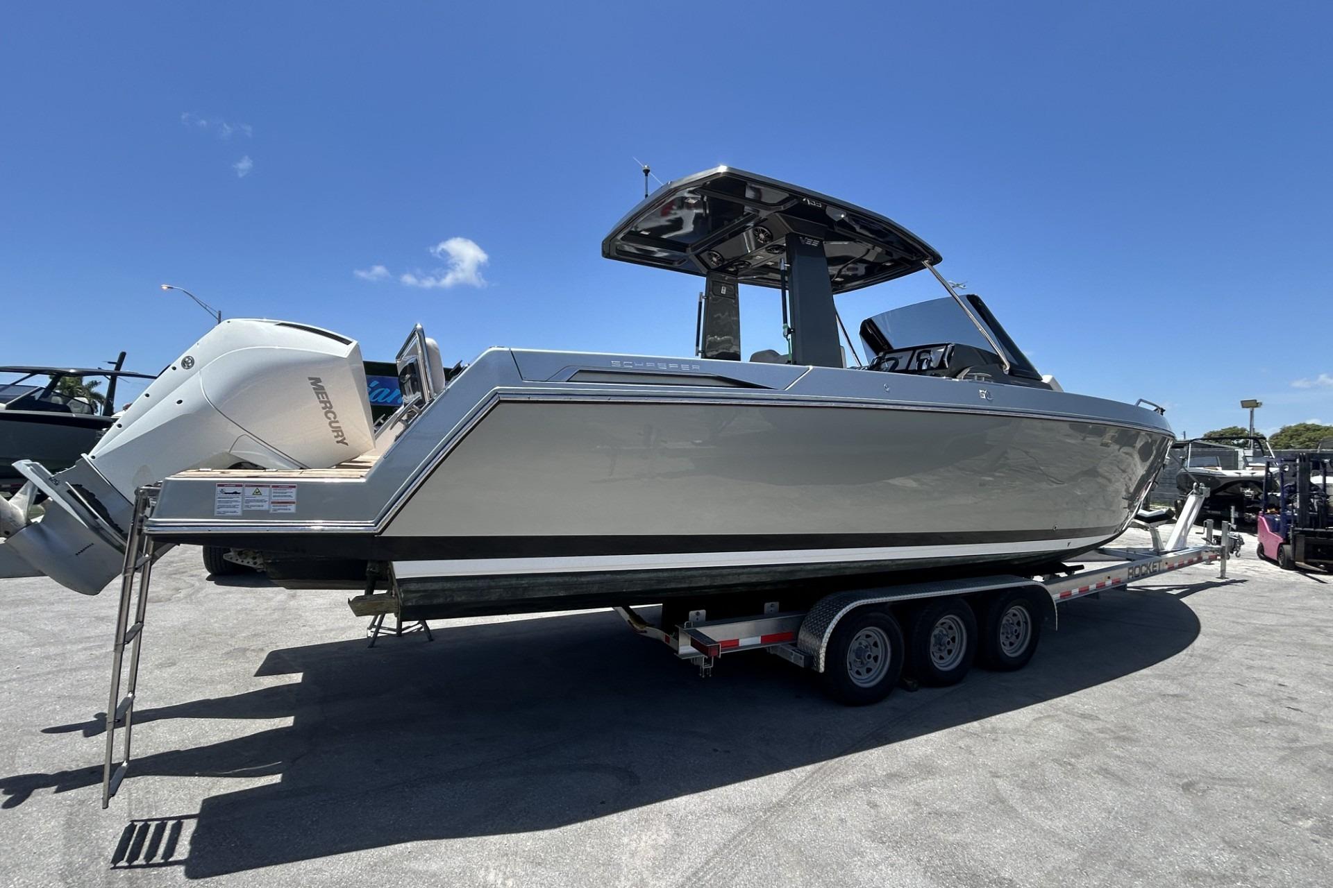 2023 Schaefer V33 boat on trailer under clear blue sky.
