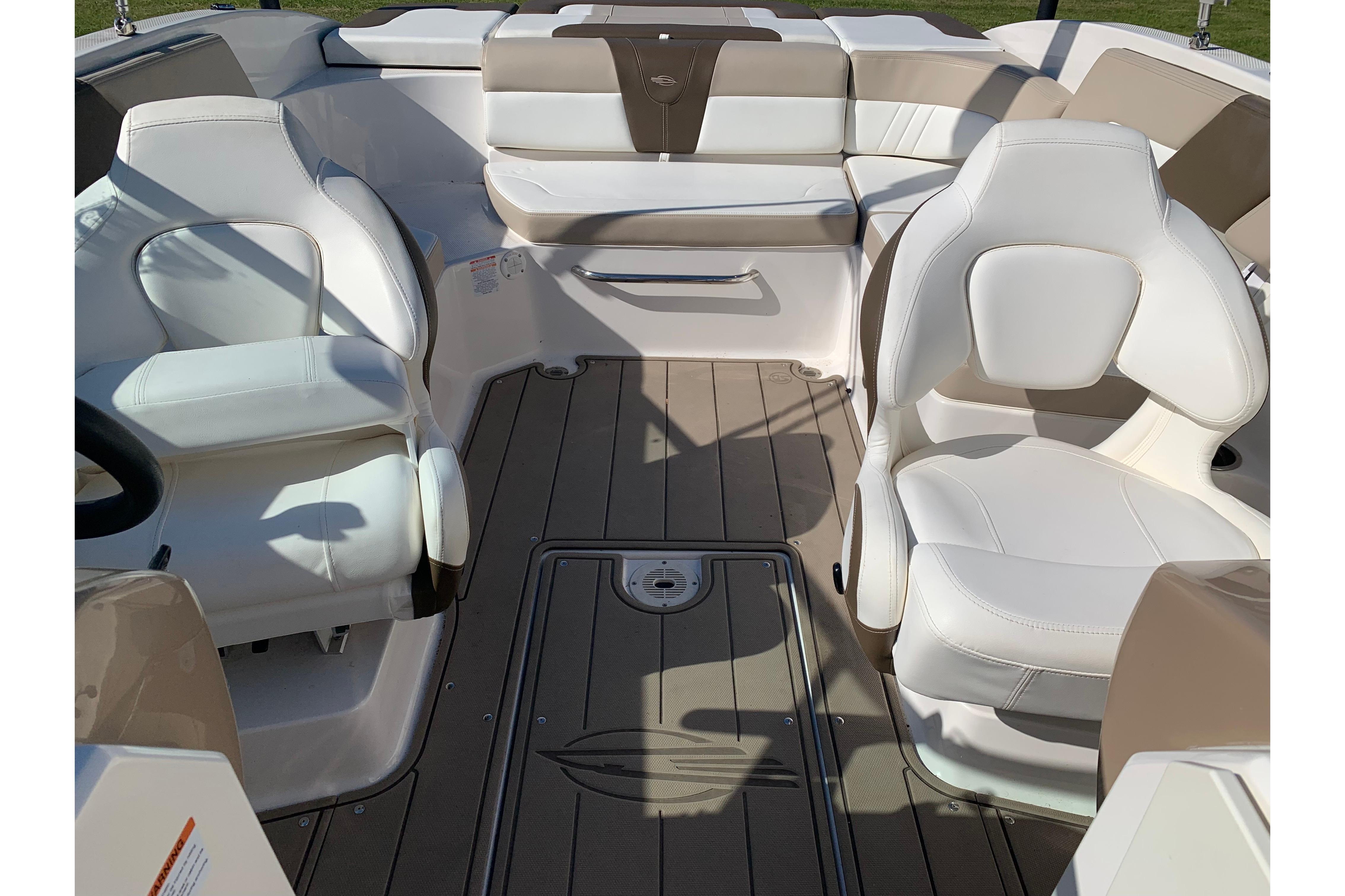 Interior of 2022 Chaparral 23 SSi boat with white seating and brown flooring.