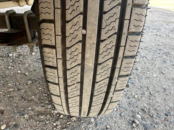 Close-up of a Larson 174 SEI 1995 tire on gravel surface, showing tread pattern.