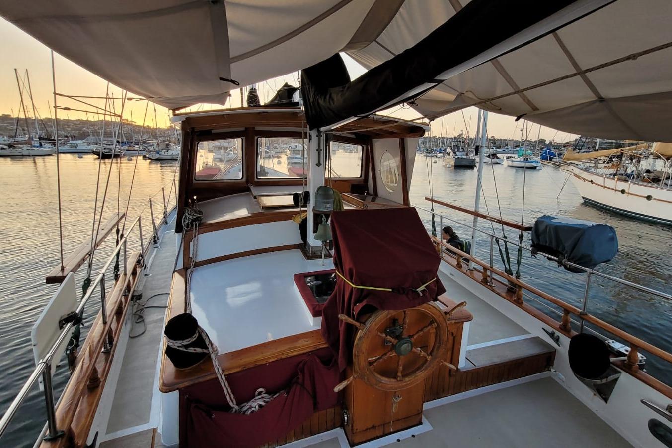 1974 Force Hudson 50 sailboat docked at marina during sunset, showcasing wooden deck and helm.