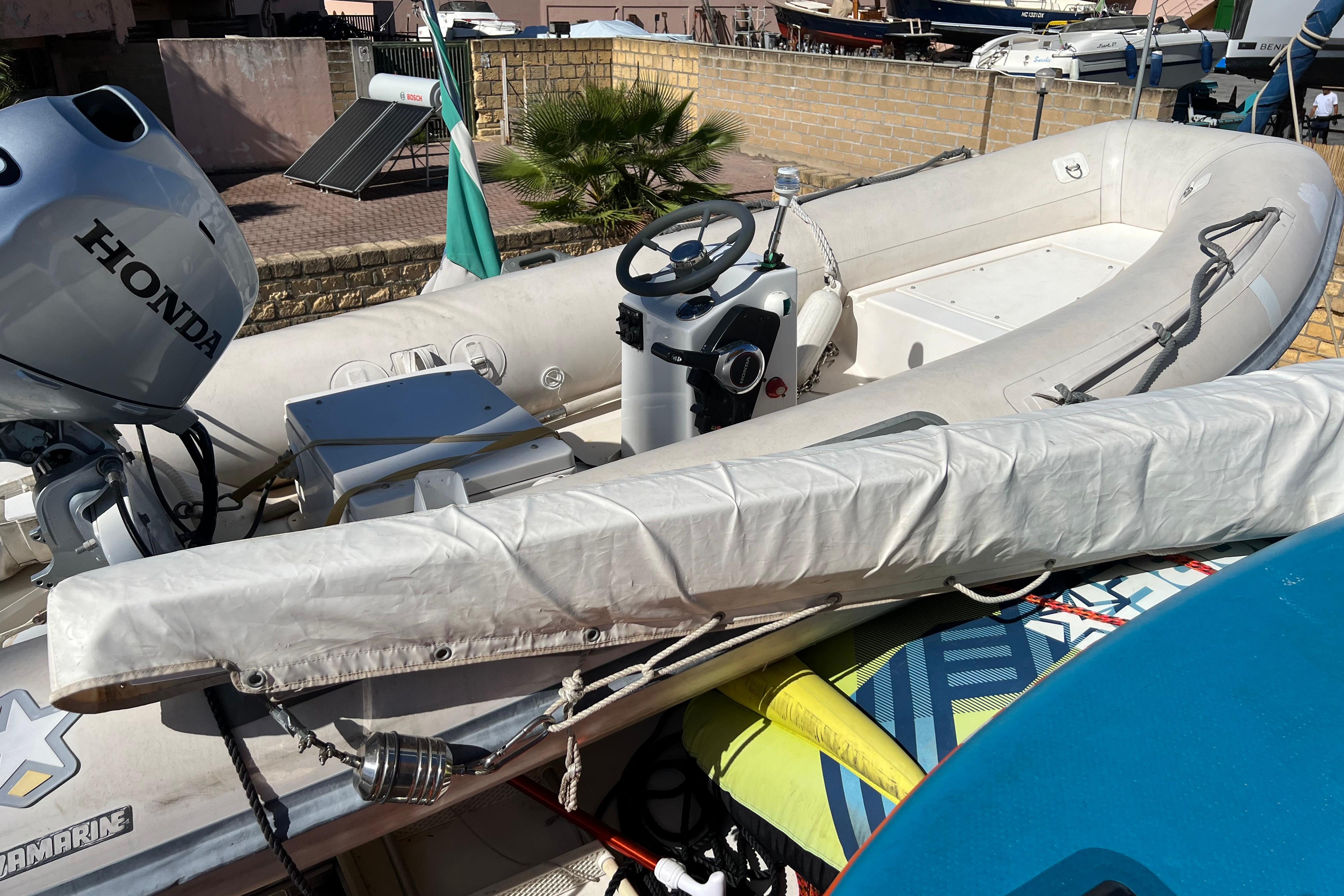 Inflatable boat with Honda motor on a Maiora 24 yacht, 2001 model, docked outdoors.