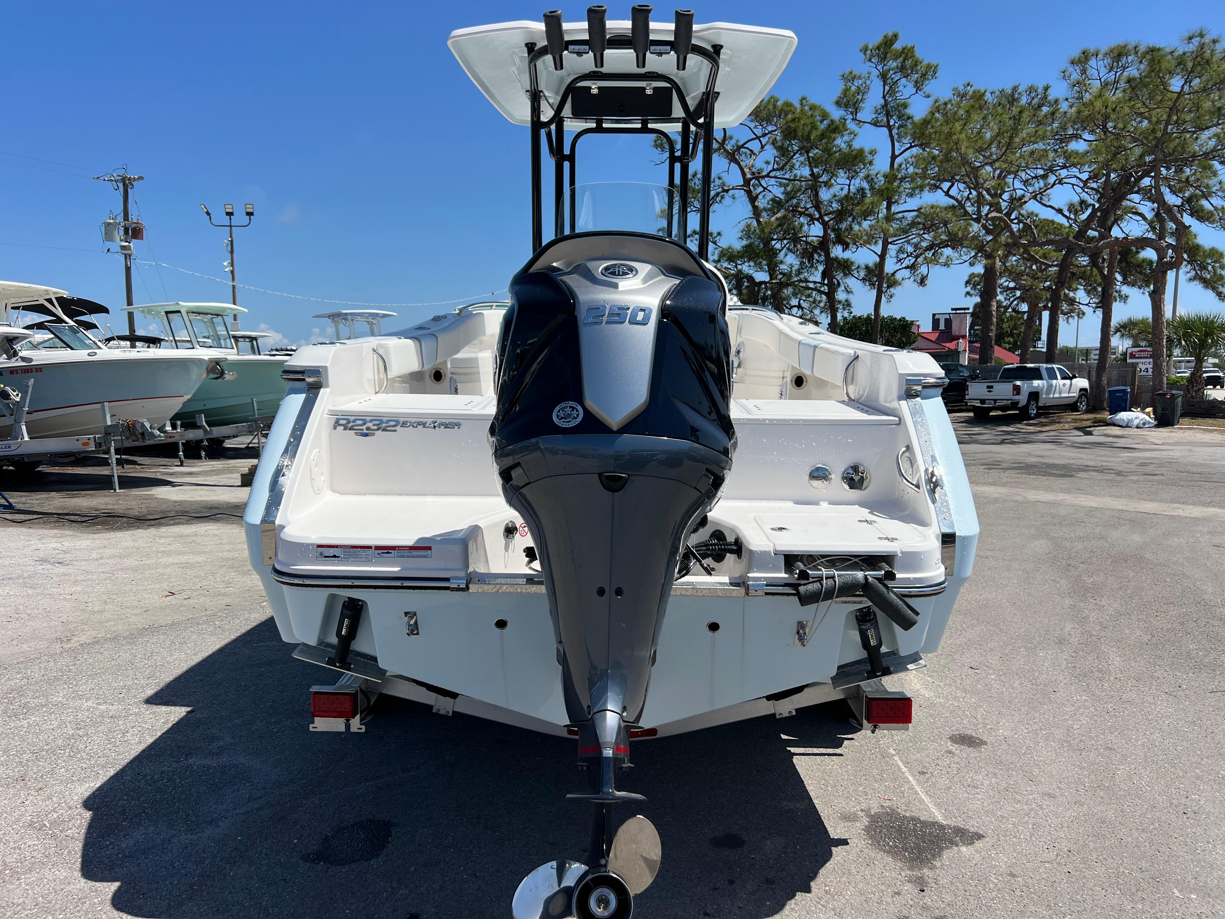 2025 Robalo R232 Explorer boat with powerful outboard motor, parked outdoors.