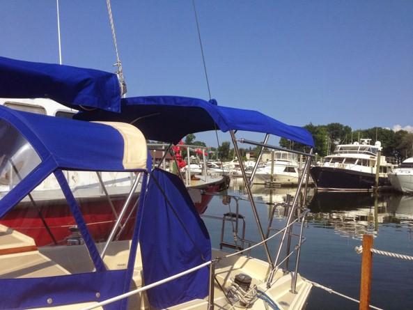 1986 O'Day 35 sailboat with blue canopy docked in a marina.
