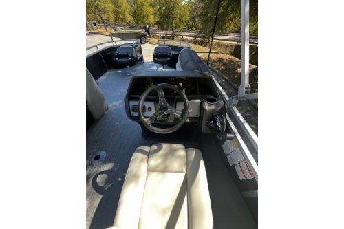 2026 Sun Tracker Fishin' Barge 22 DLX interior with steering wheel and seating.