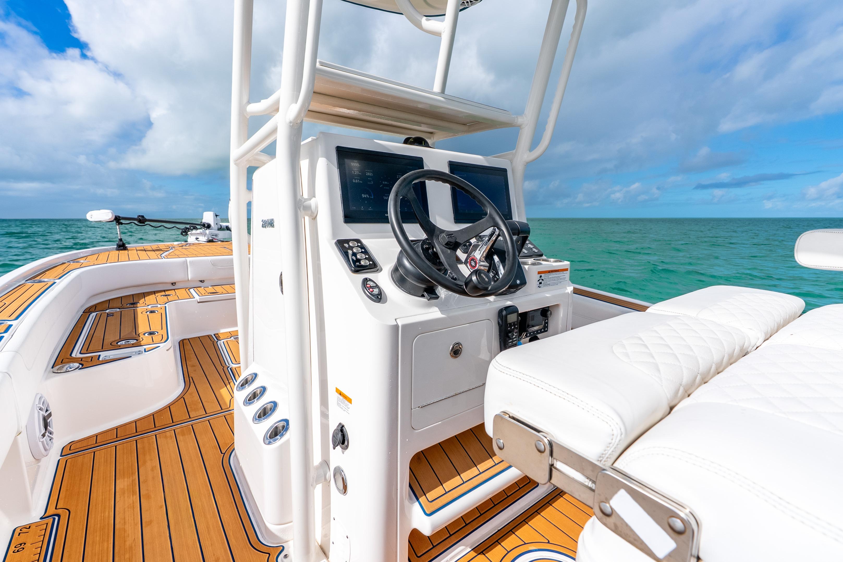 2024 Caymas 281 HB boat interior with helm, ocean view, and teak flooring.