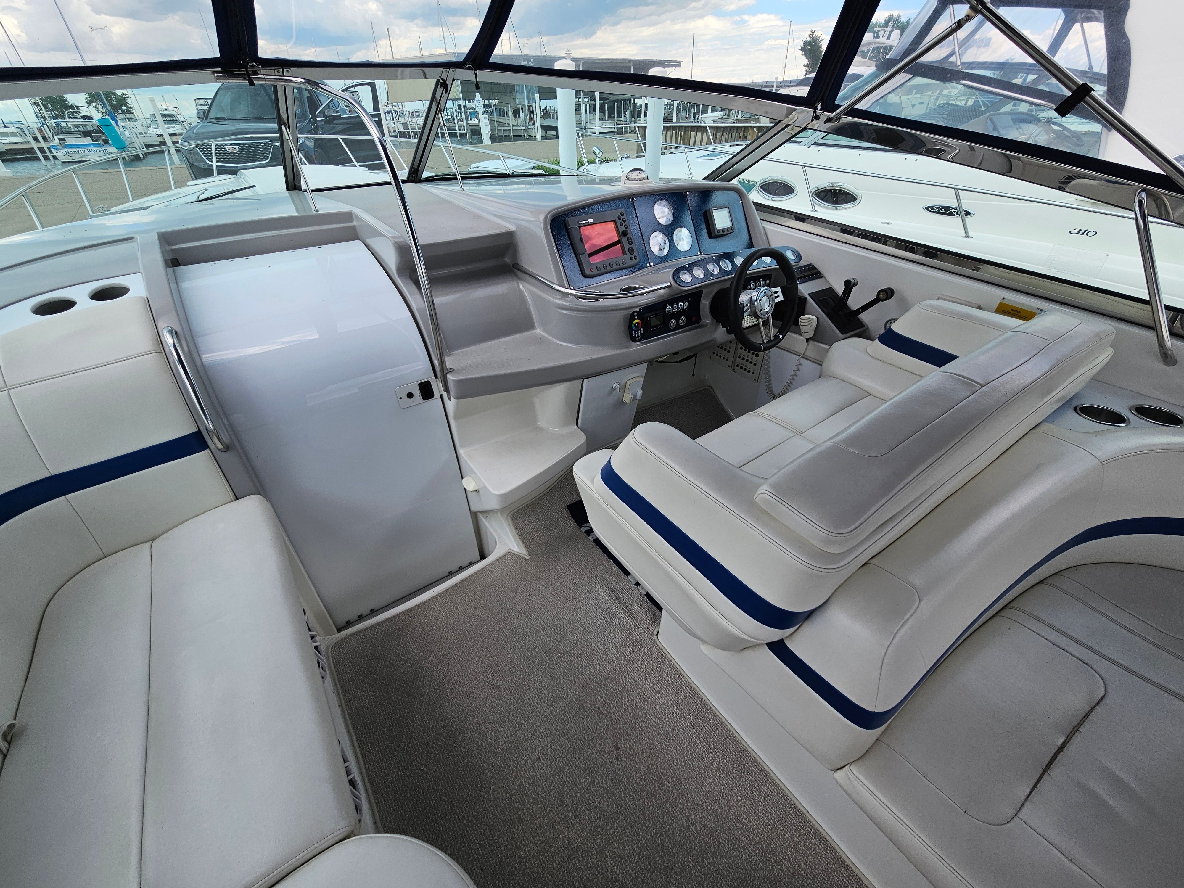 The cockpit of a 2001 Formula 400 Super Sport with white seating and a modern helm.