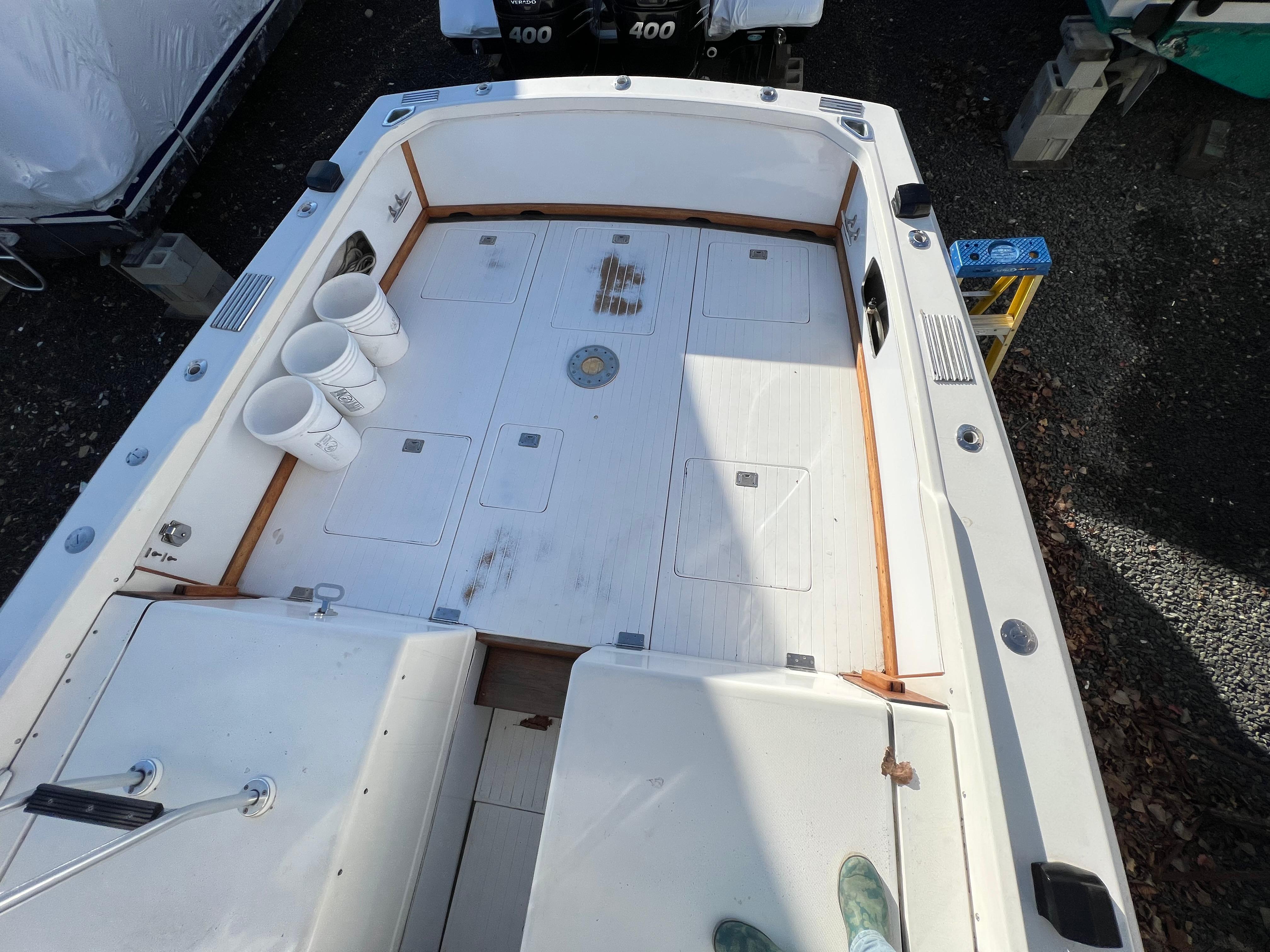 1973 Bertram 31 Flybridge Cruiser deck with storage compartments and fishing gear.