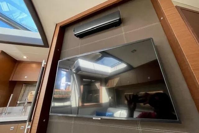 Interior of 2016 Sea Ray Sundancer 510 yacht with mounted TV and skylight.