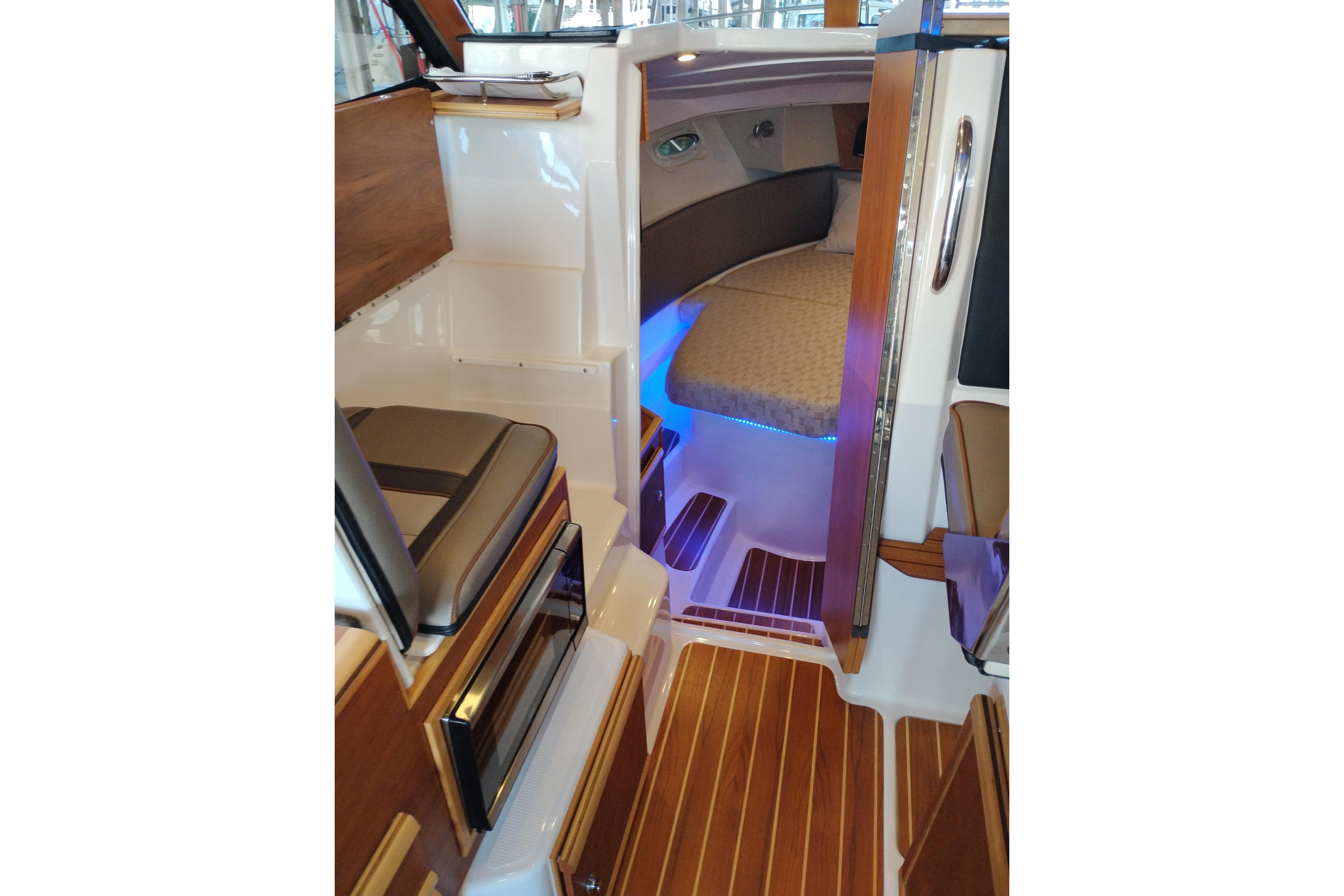 Interior of 2022 Cutwater C-32 Coupe, featuring elegant wood flooring and cozy seating.