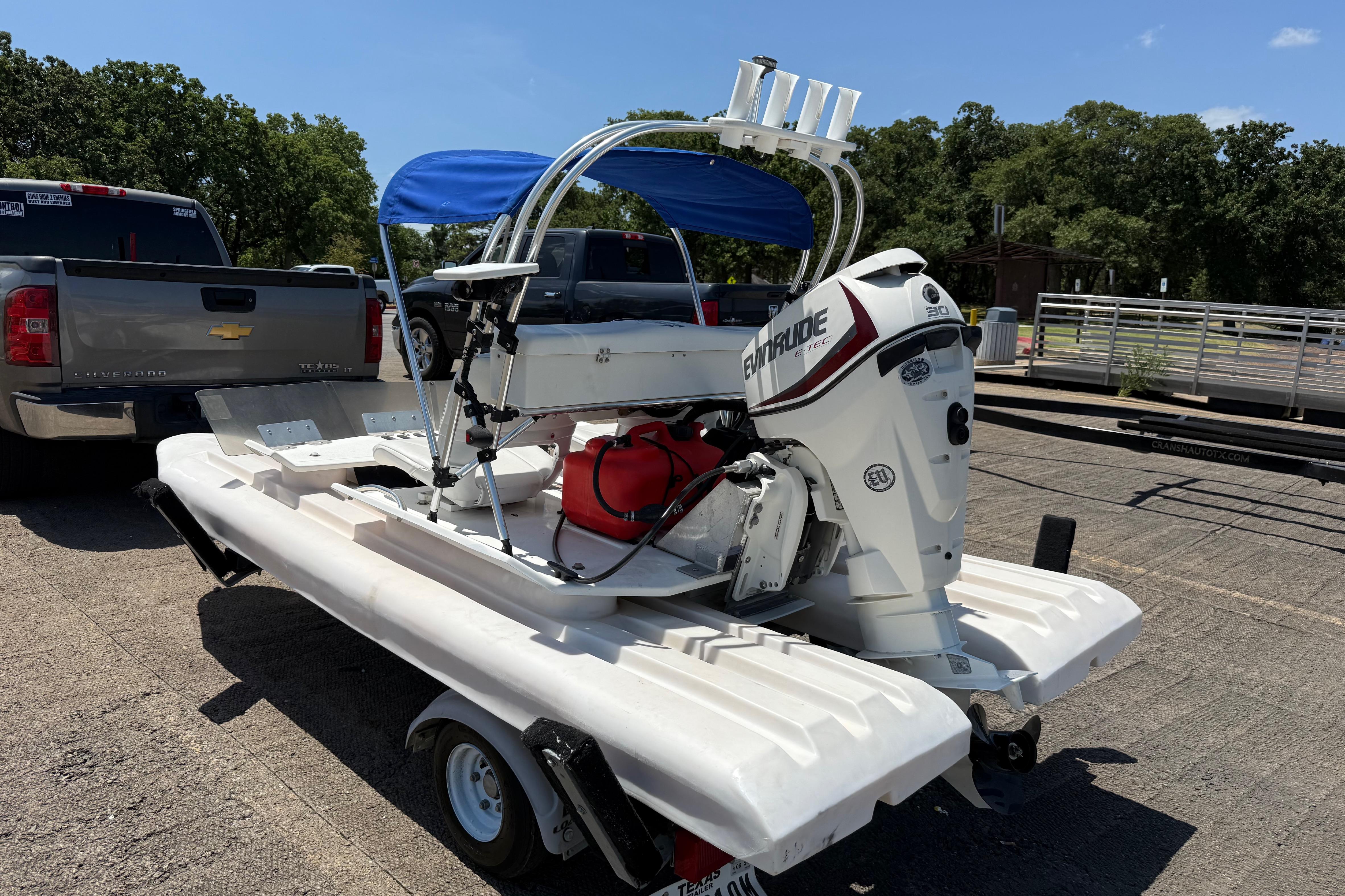 2016 CraigCat E2 Elite boat on trailer with Evinrude motor, parked near a truck.