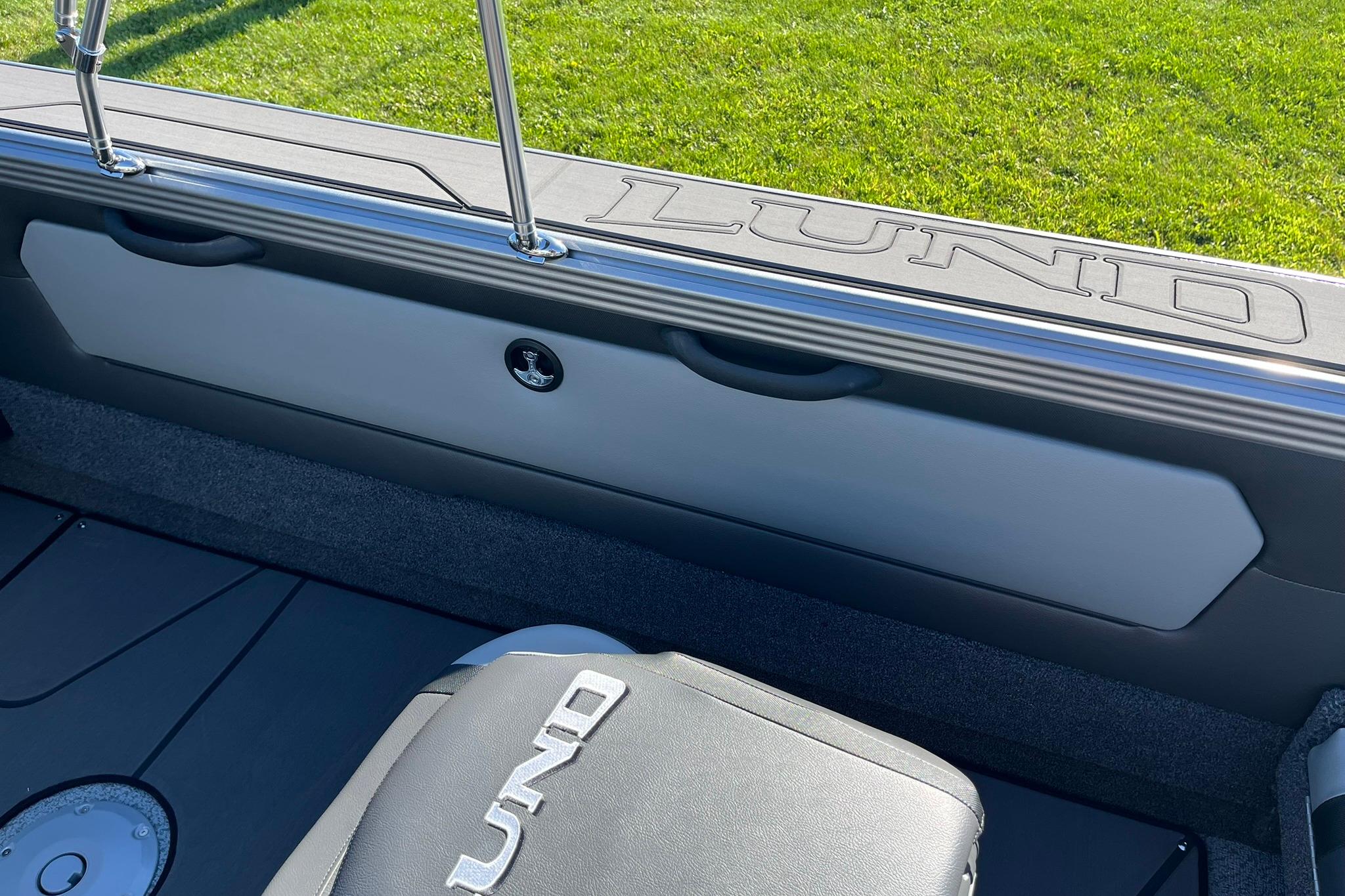 2026 Lund 2275 Baron boat interior with logo, featuring sleek seating and storage.