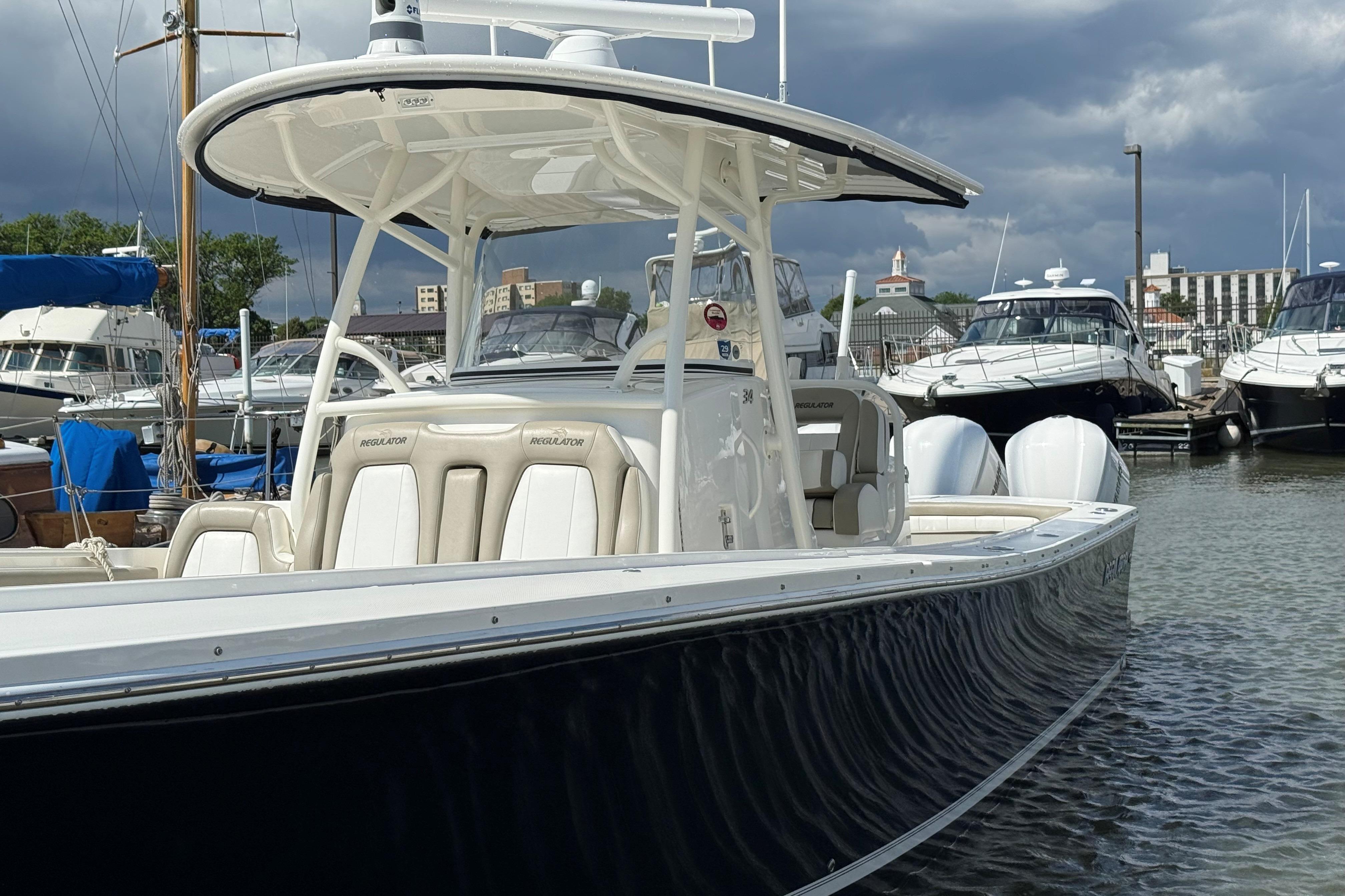 2019 Regulator 34SS boat docked in a marina under cloudy skies.