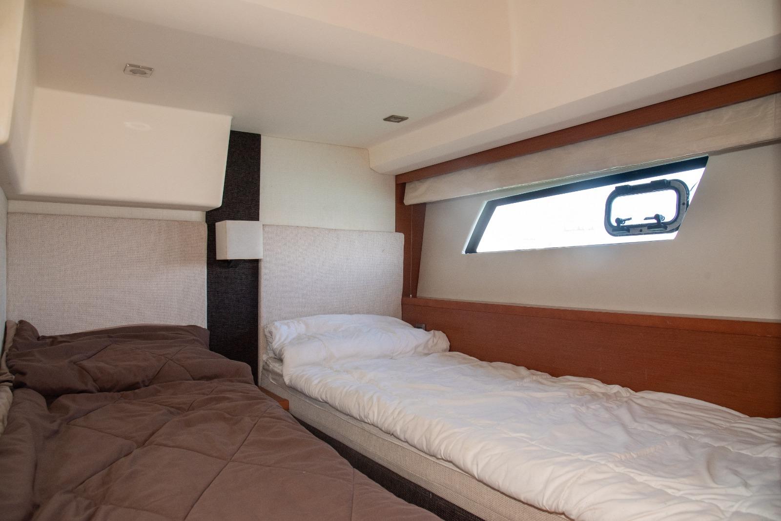 Interior cabin of 2013 Prestige 500 S yacht with twin beds and window.