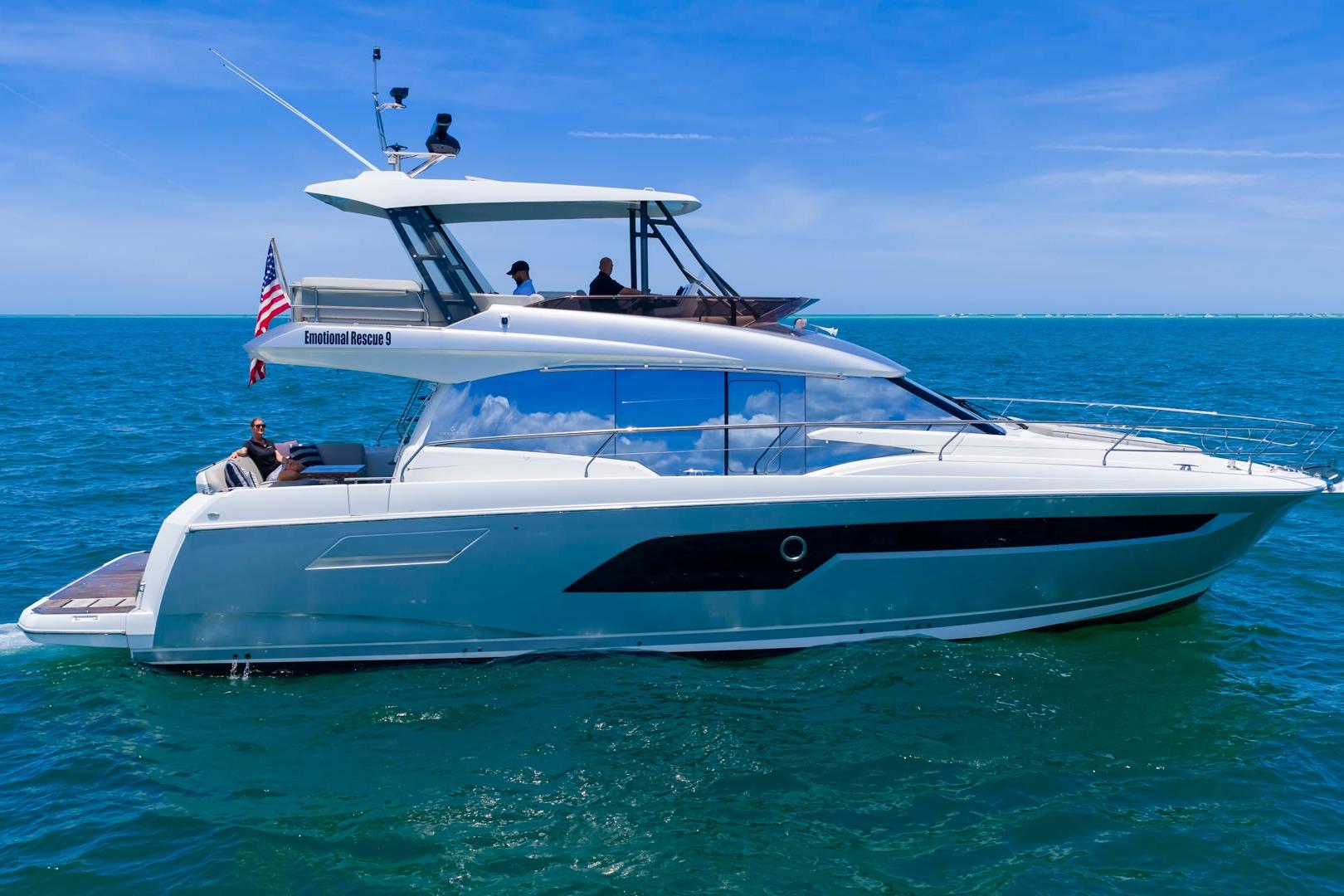 2022 Prestige 520 yacht cruising on open sea under clear blue sky.