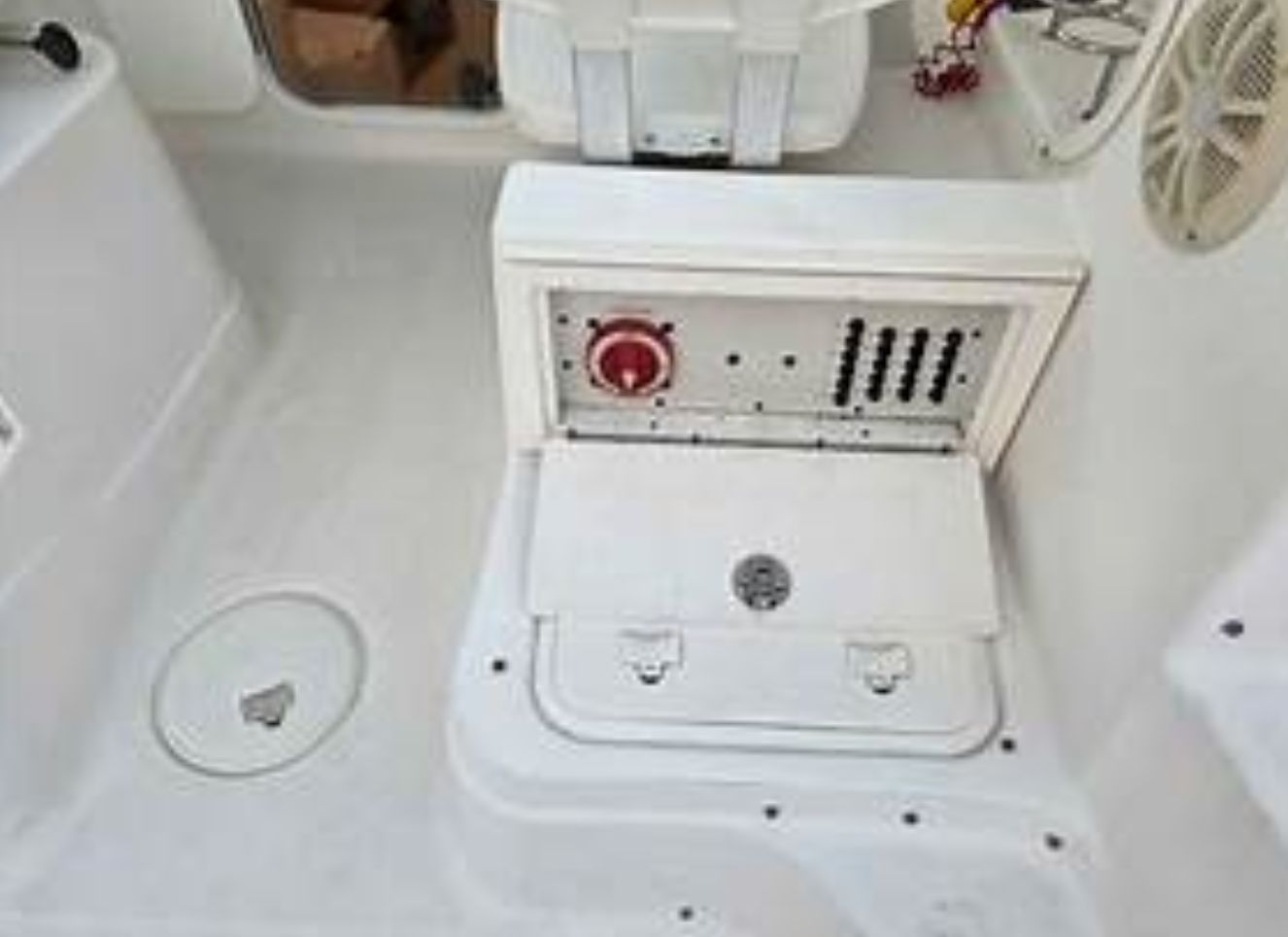 The image shows a boat's control area with switches and a red knob.