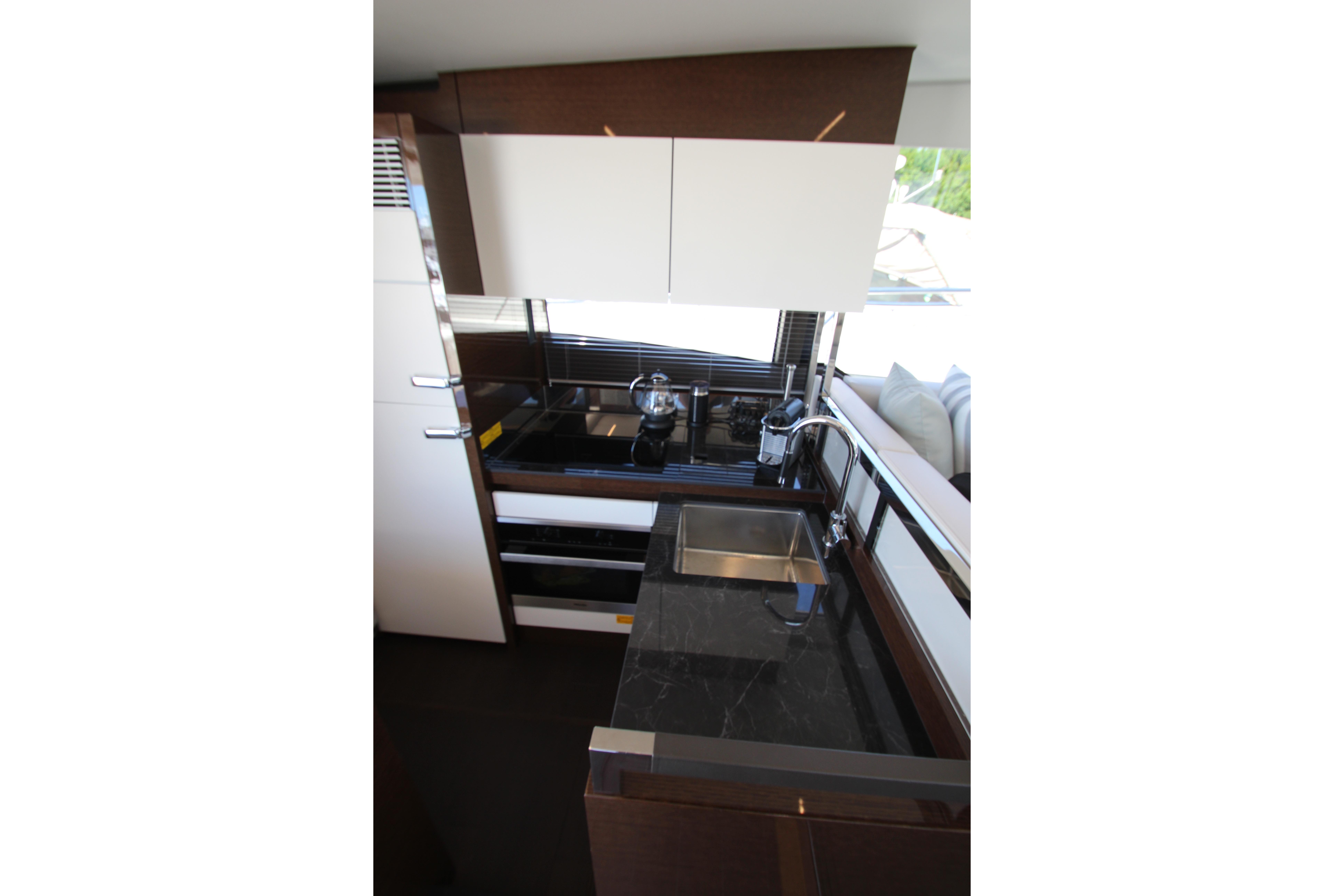 Modern kitchen interior of 2022 Prestige 520 yacht with sleek design and appliances.