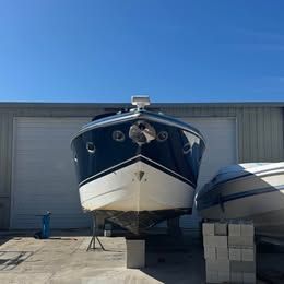 A 2003 Cobalt 360 is on a dry dock in front of a warehouse.