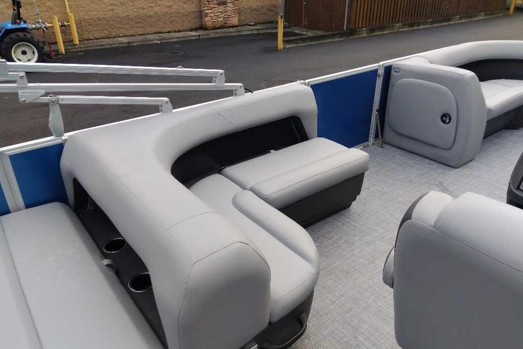 2026 Sun Tracker Party Barge 18 DLX interior with gray seating and cup holders.