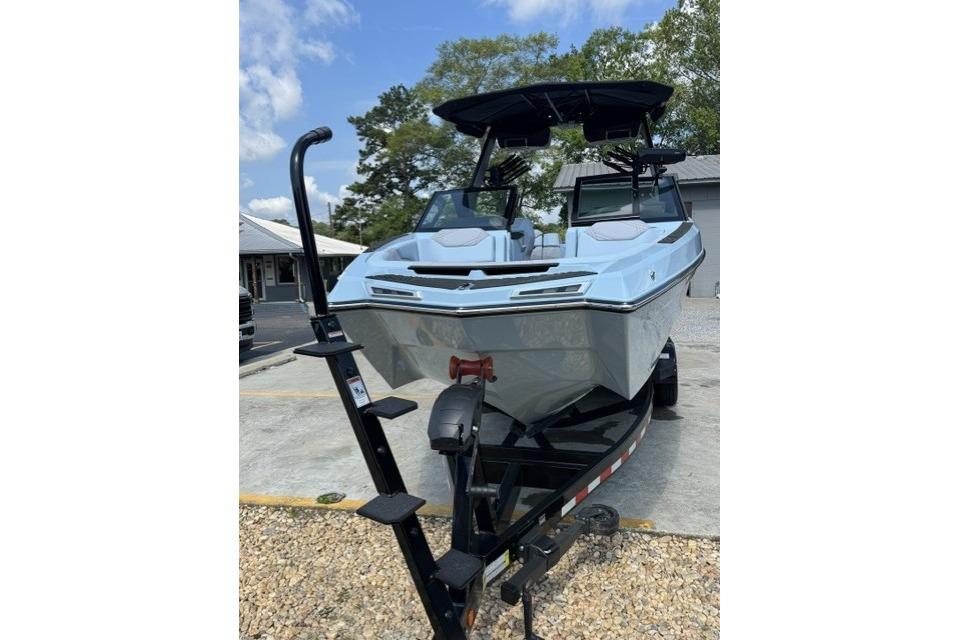 2026 MasterCraft XStar 25 boat on trailer, parked outdoors under a clear sky.