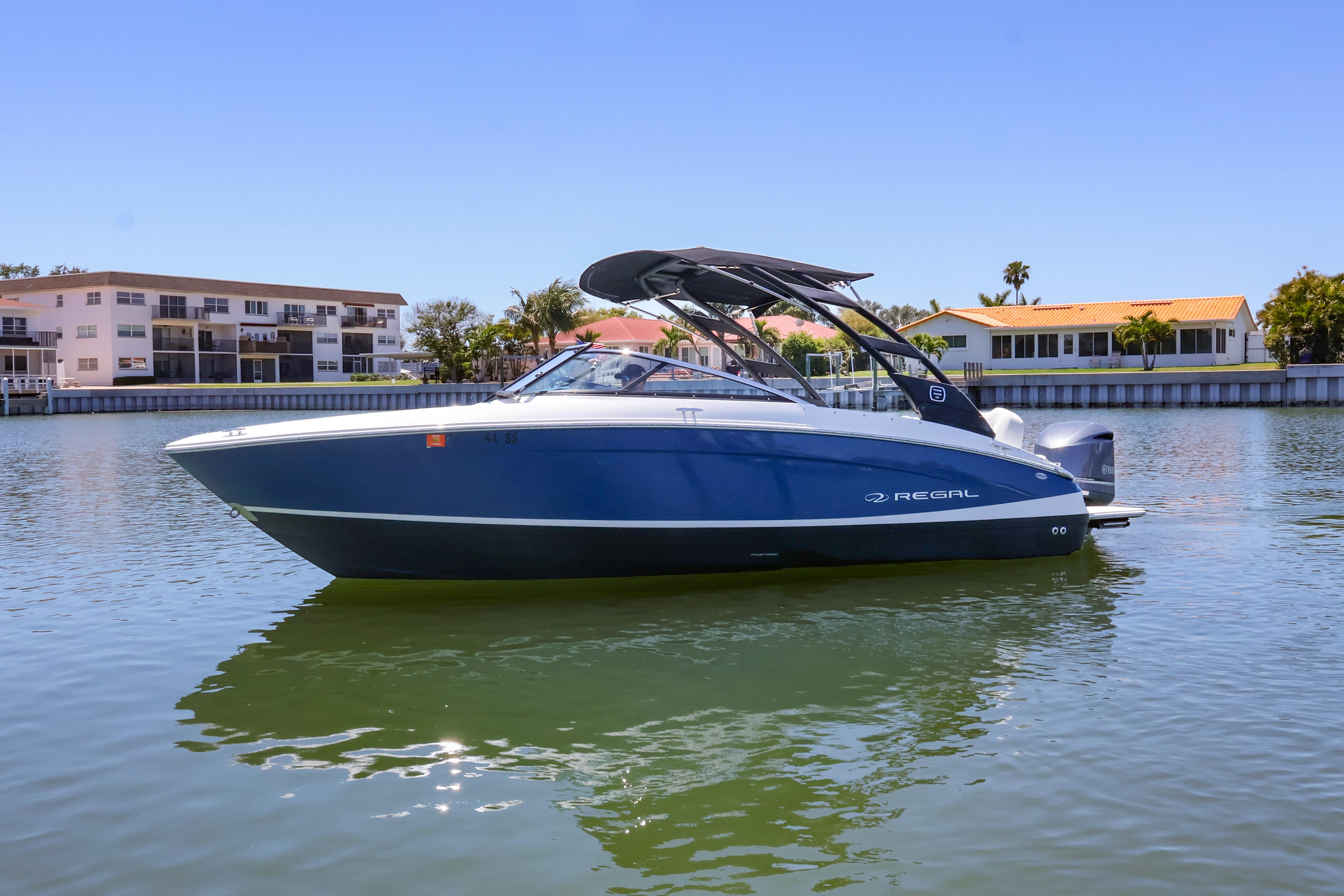 2020 Regal LX4 boat on calm water with residential backdrop.