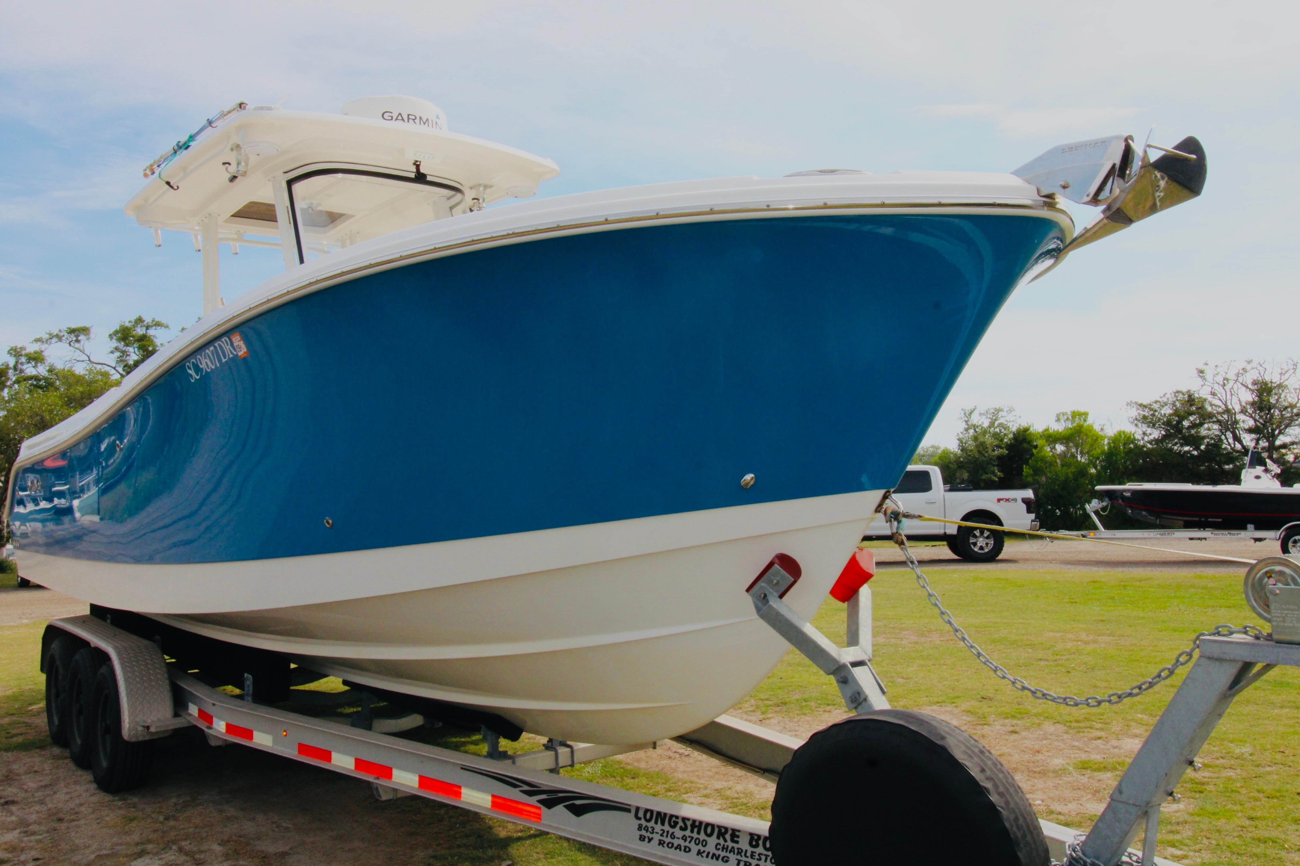 2022 Edgewater 280CC boat on trailer, blue hull, parked outdoors.