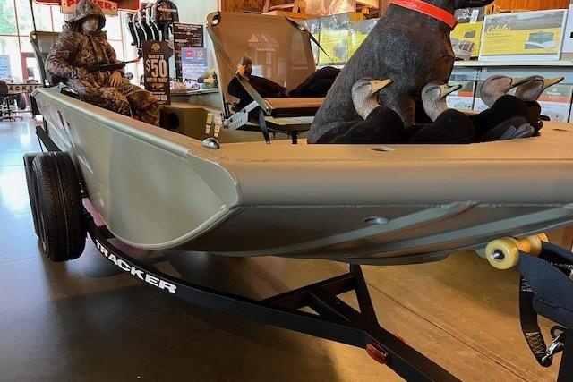 2026 Tracker Grizzly 1650 T Prairie Wings Edition boat displayed indoors with hunting gear.
