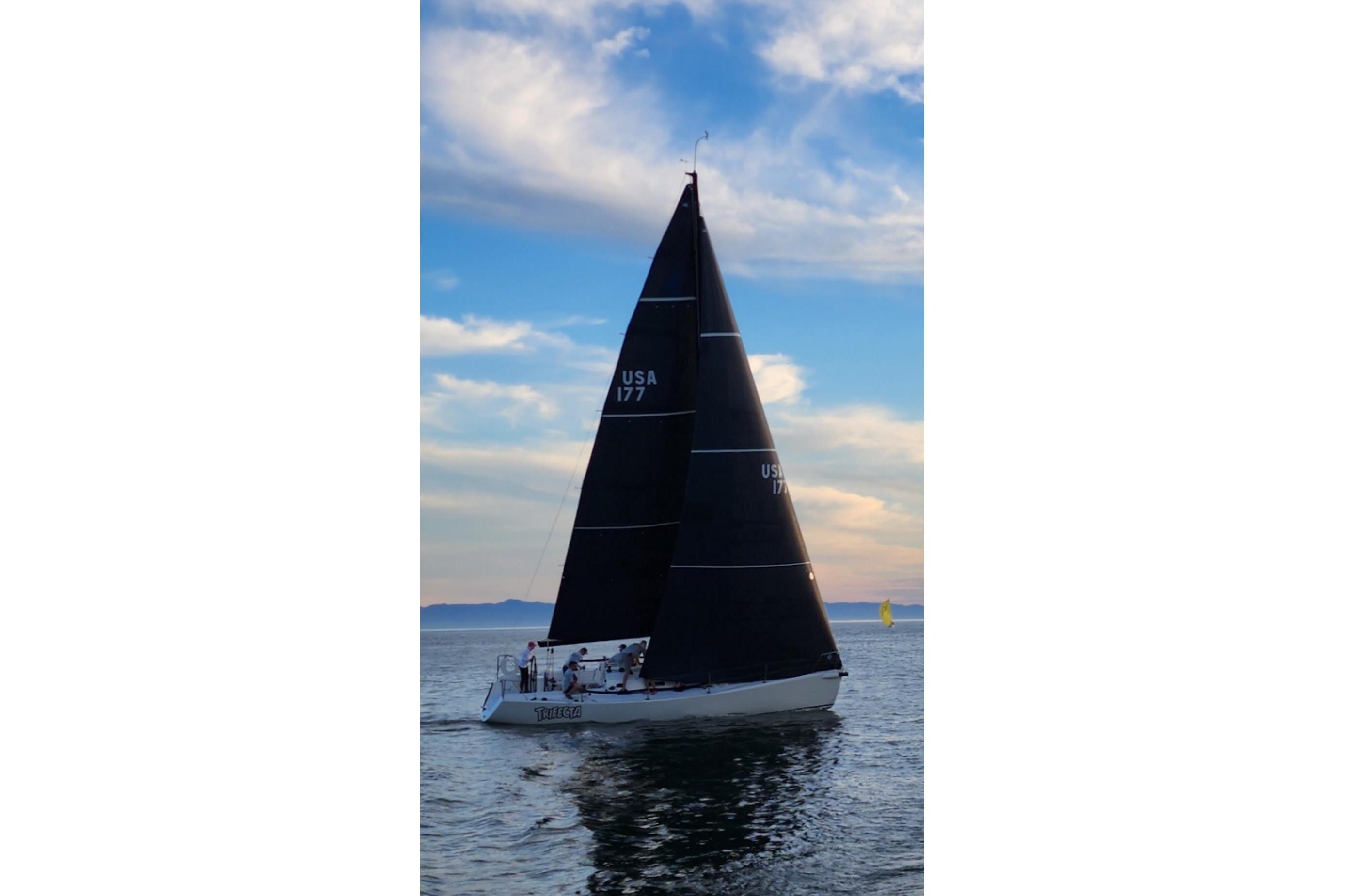 2004 J Boats J/109 sailing on calm waters at sunset.
