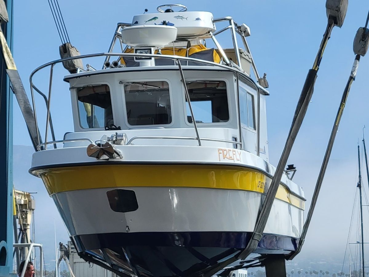 A 2008 Davis-Radon RockHarbor Long Cabin boat being lifted out of the water by a crane.