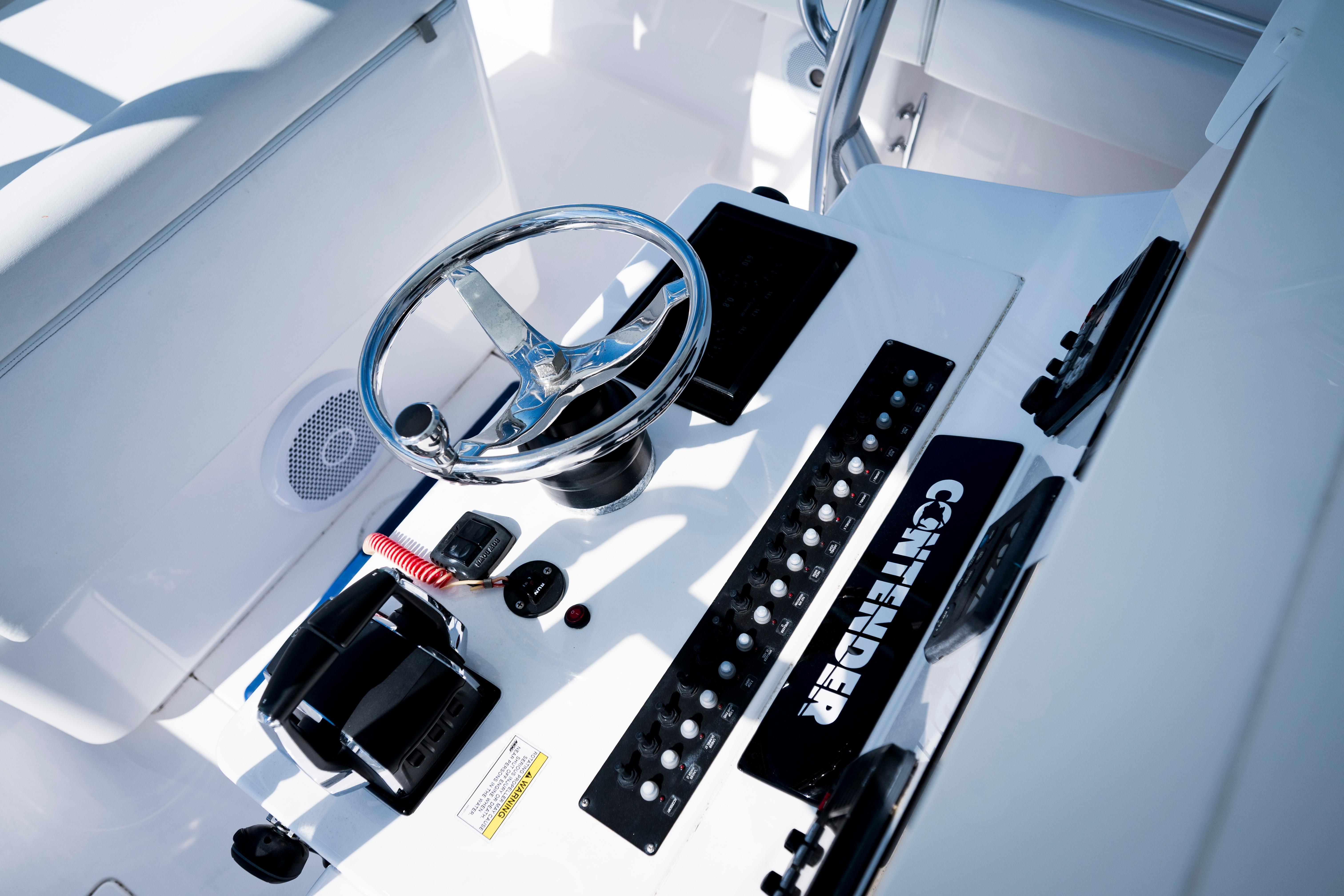 Helm of 2015 Contender 39 ST boat with steering wheel and control panel.