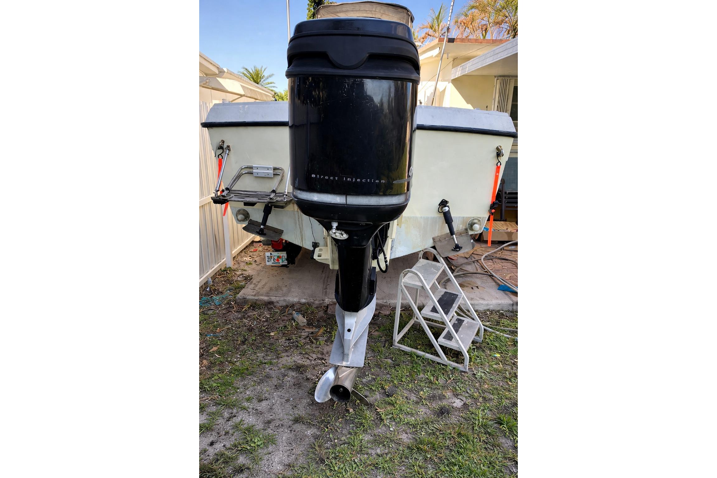 1989 Grady-White Offshore 242 boat with outboard motor, parked on grass.