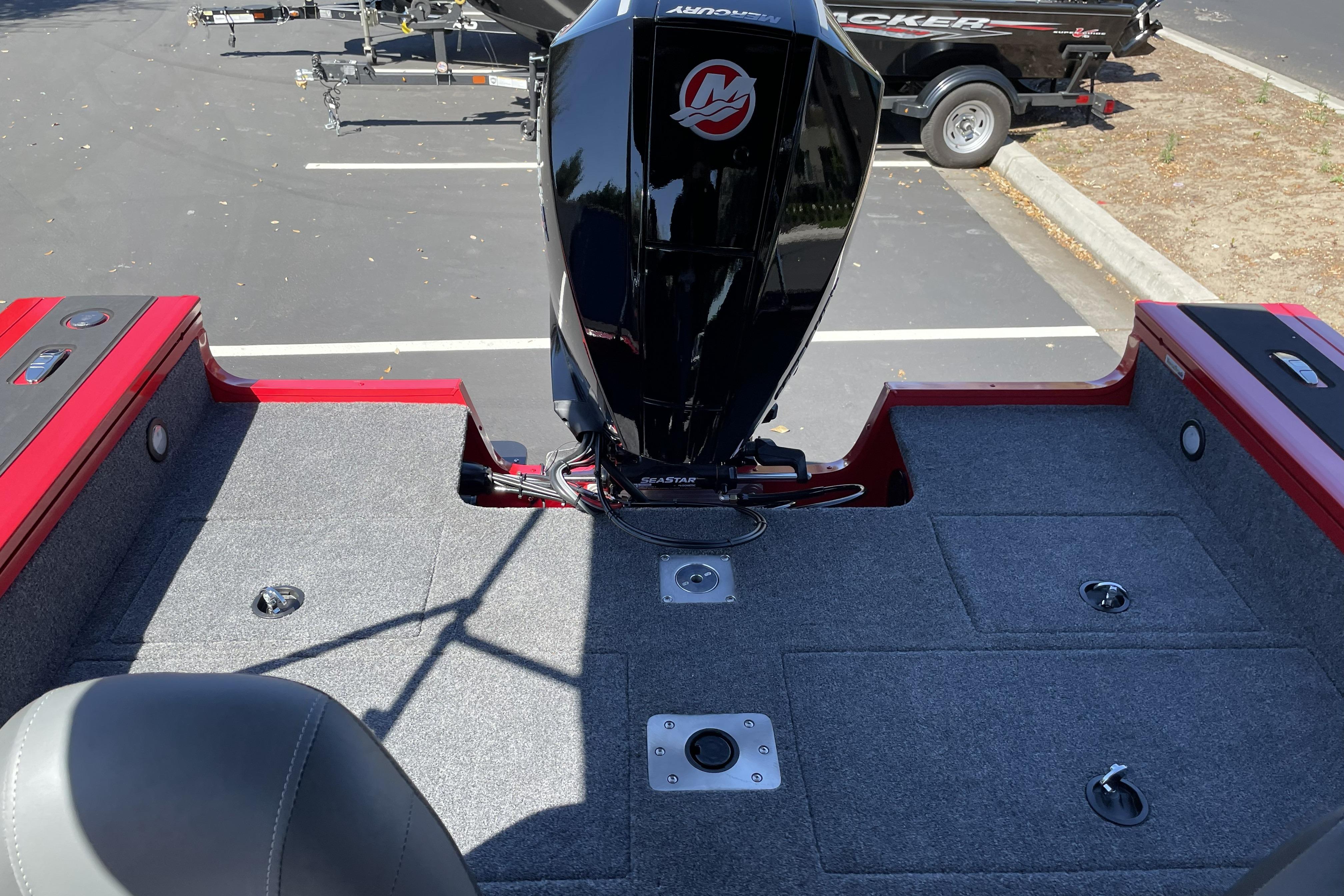 2026 Tracker Targa V-18 WT boat interior with motor, gray carpet, and storage compartments.