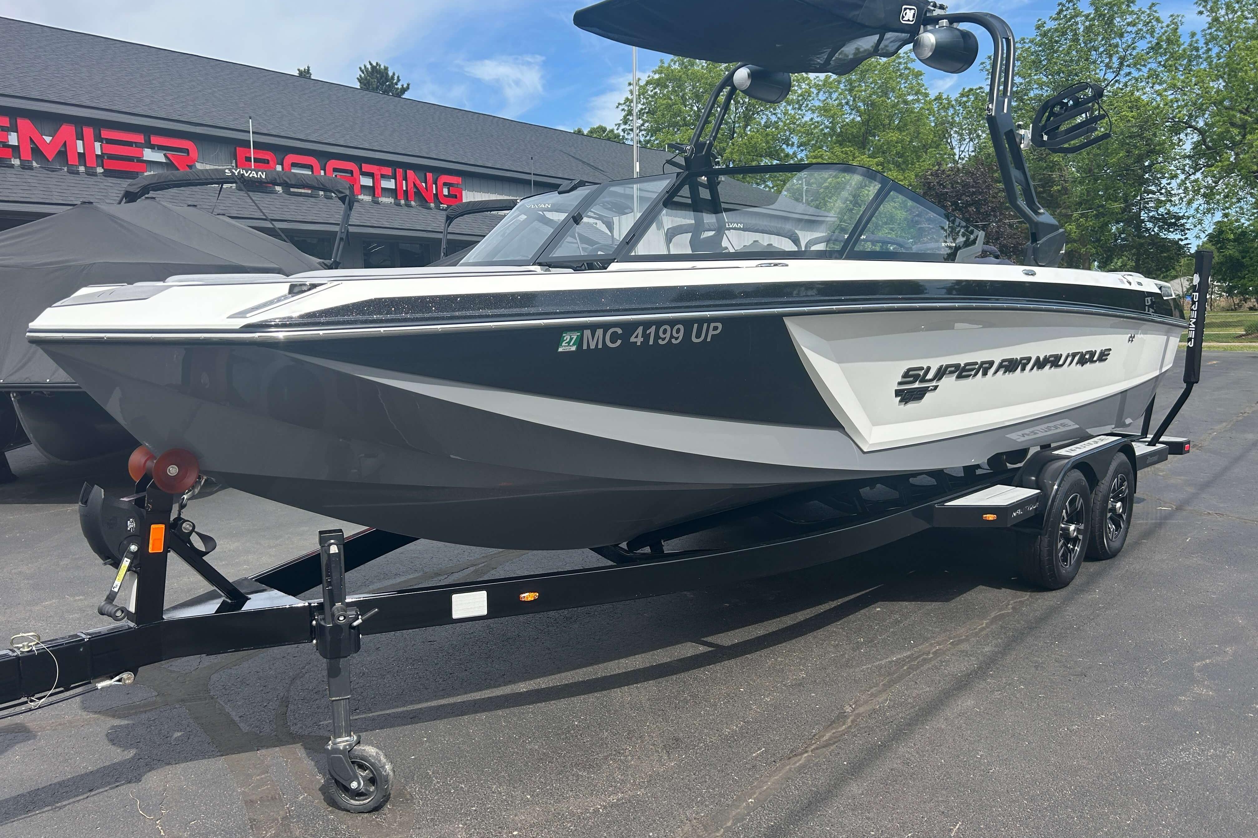 2021 Nautique Super Air Nautique GS24 boat on trailer, parked outside dealership.