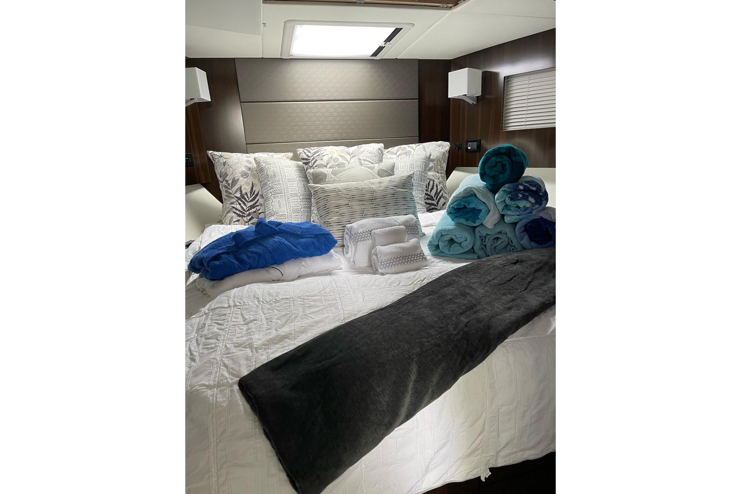 Luxurious bedroom in 2022 Cruisers Yachts 42 Cantius with plush bedding and towels.