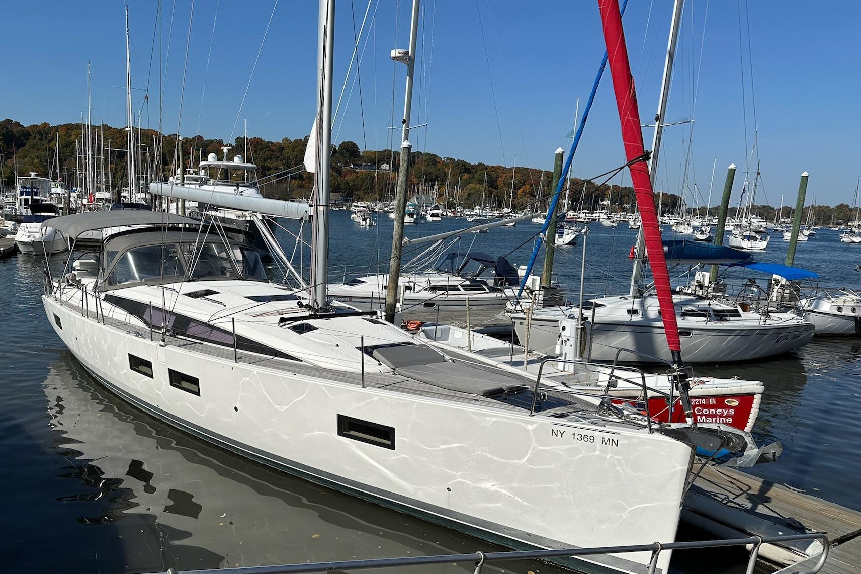 2018 Jeanneau 51 sailboat docked in a marina, surrounded by other boats.