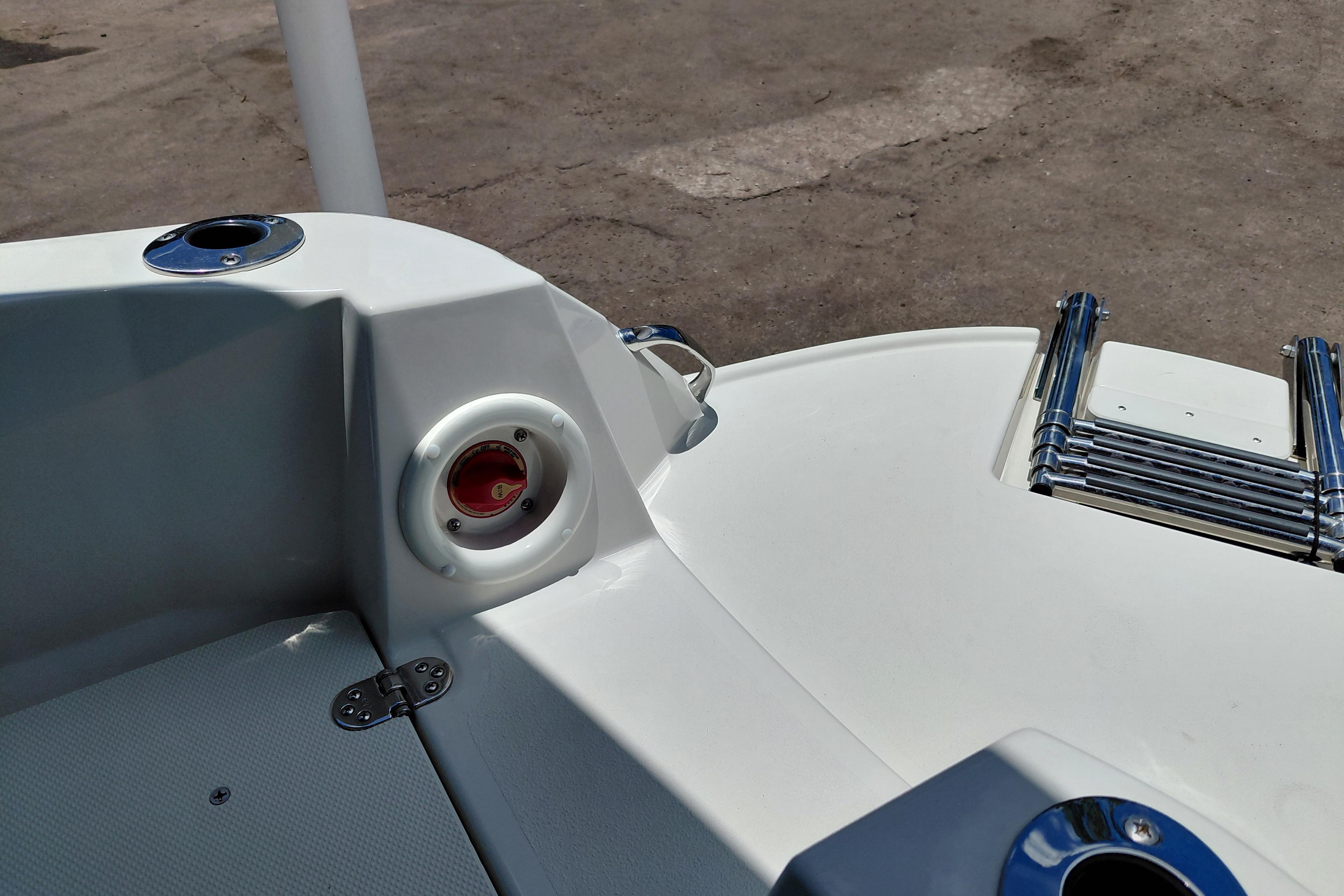 2023 Stingray 206 CC boat stern with ladder and cup holder, docked on concrete surface.