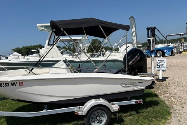 2024 Boston Whaler 130 Super Sport boat on trailer, parked outdoors with canopy.