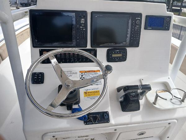 Control panel of 2015 Sea Fox 286 Commander boat with steering wheel and navigation screens.
